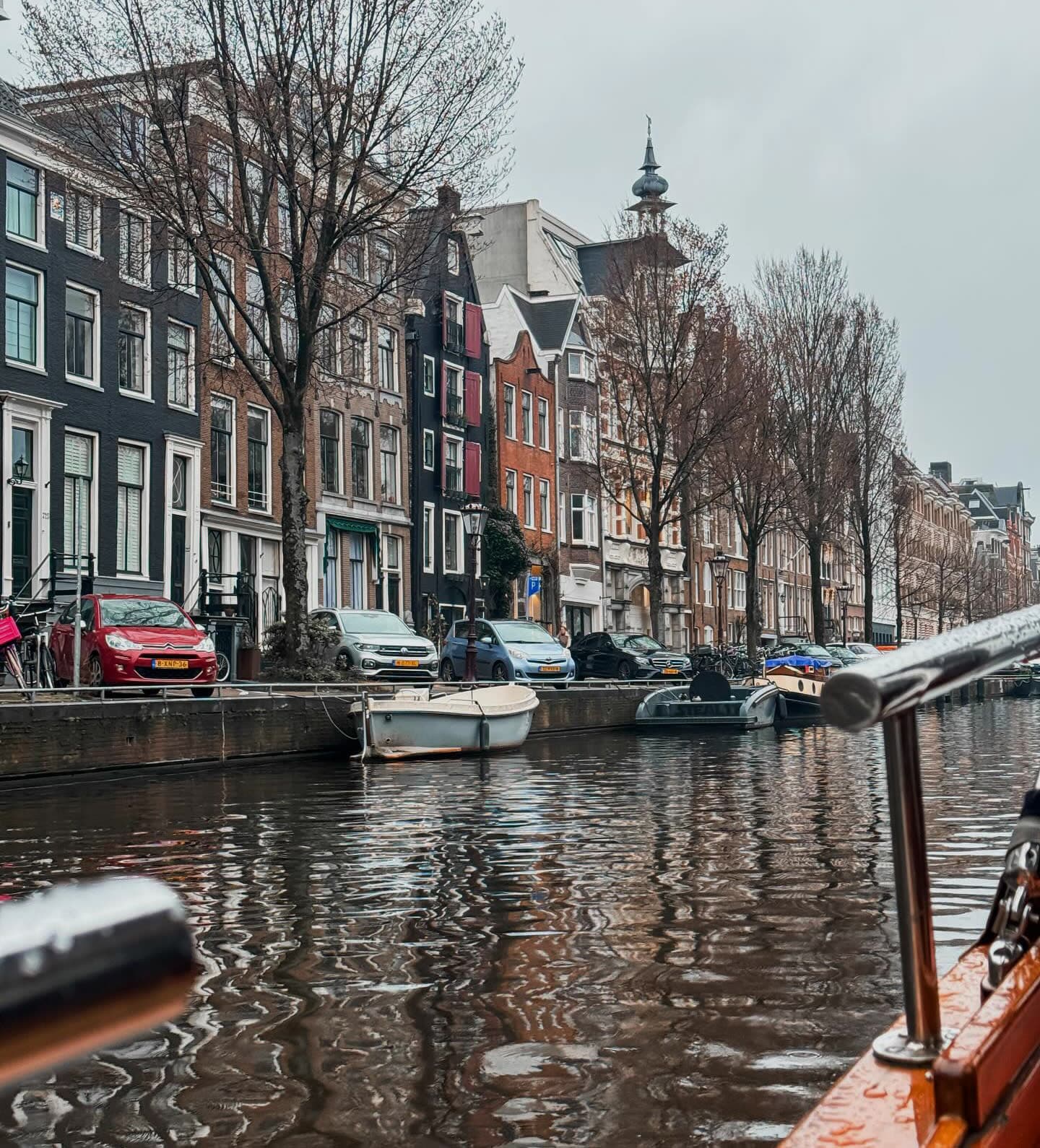 A canal in Amsterdam lined with houses and trees