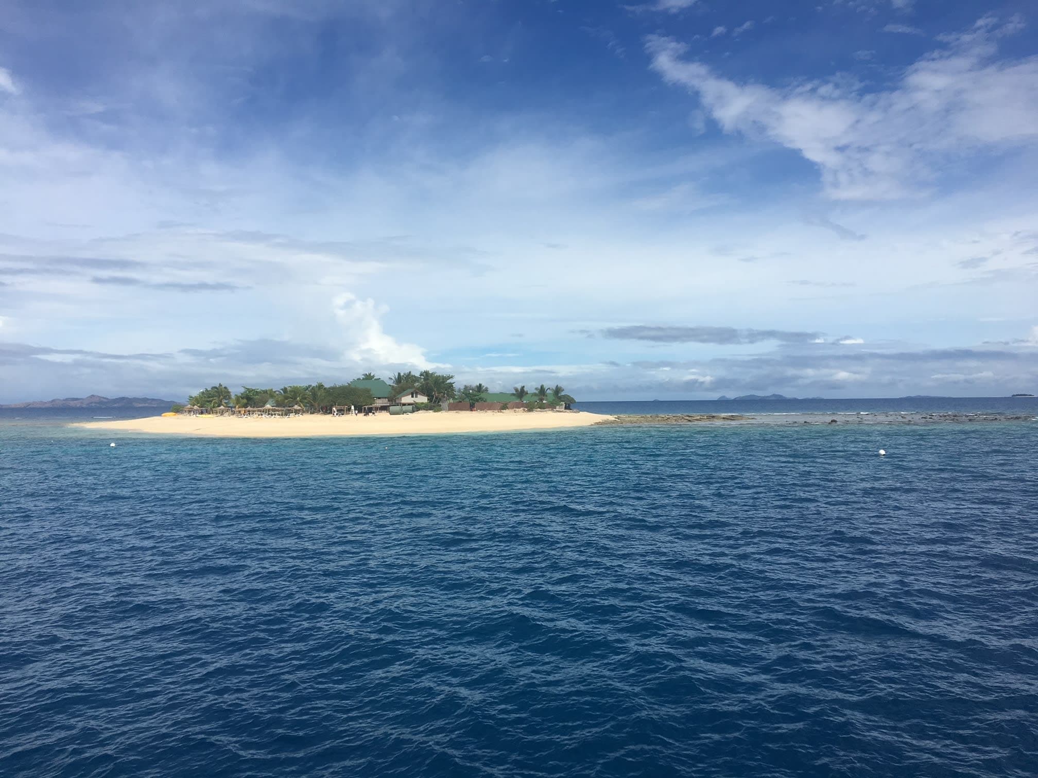 The ocean on a sunny day with an island in the distance