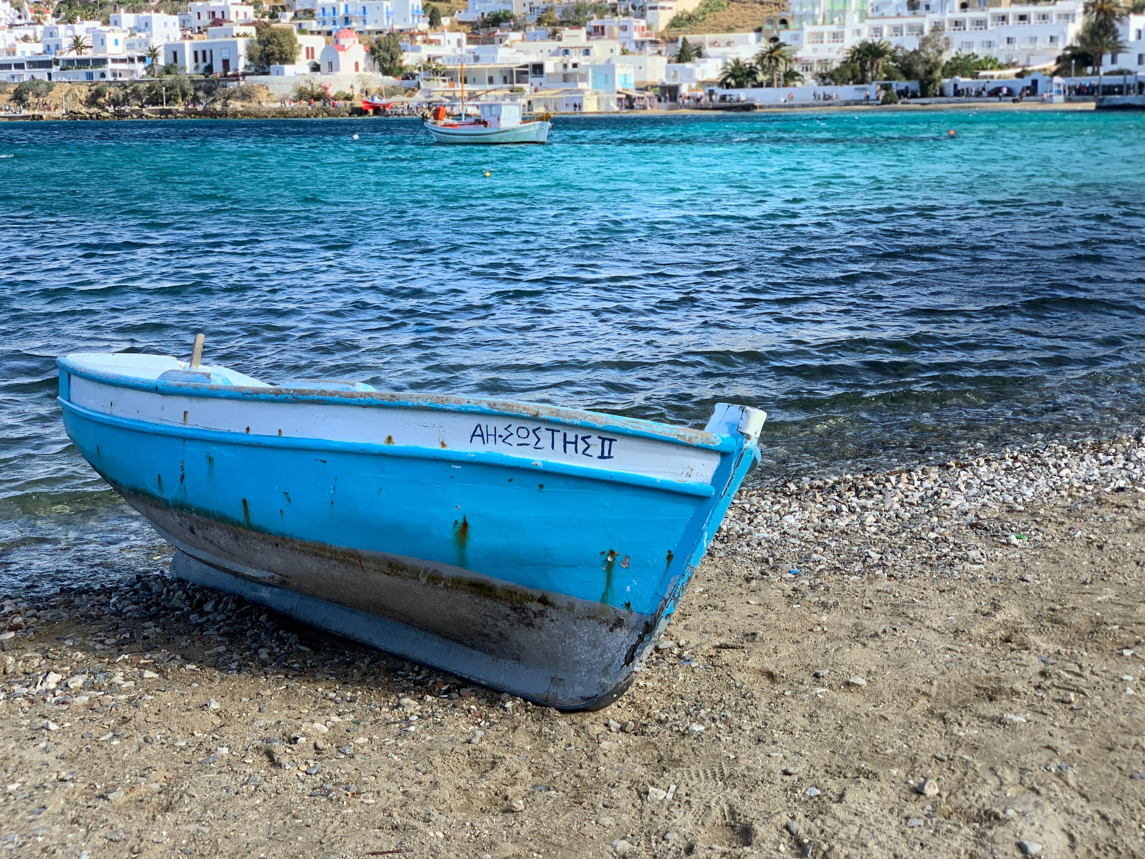 A small light blue boat on the shore