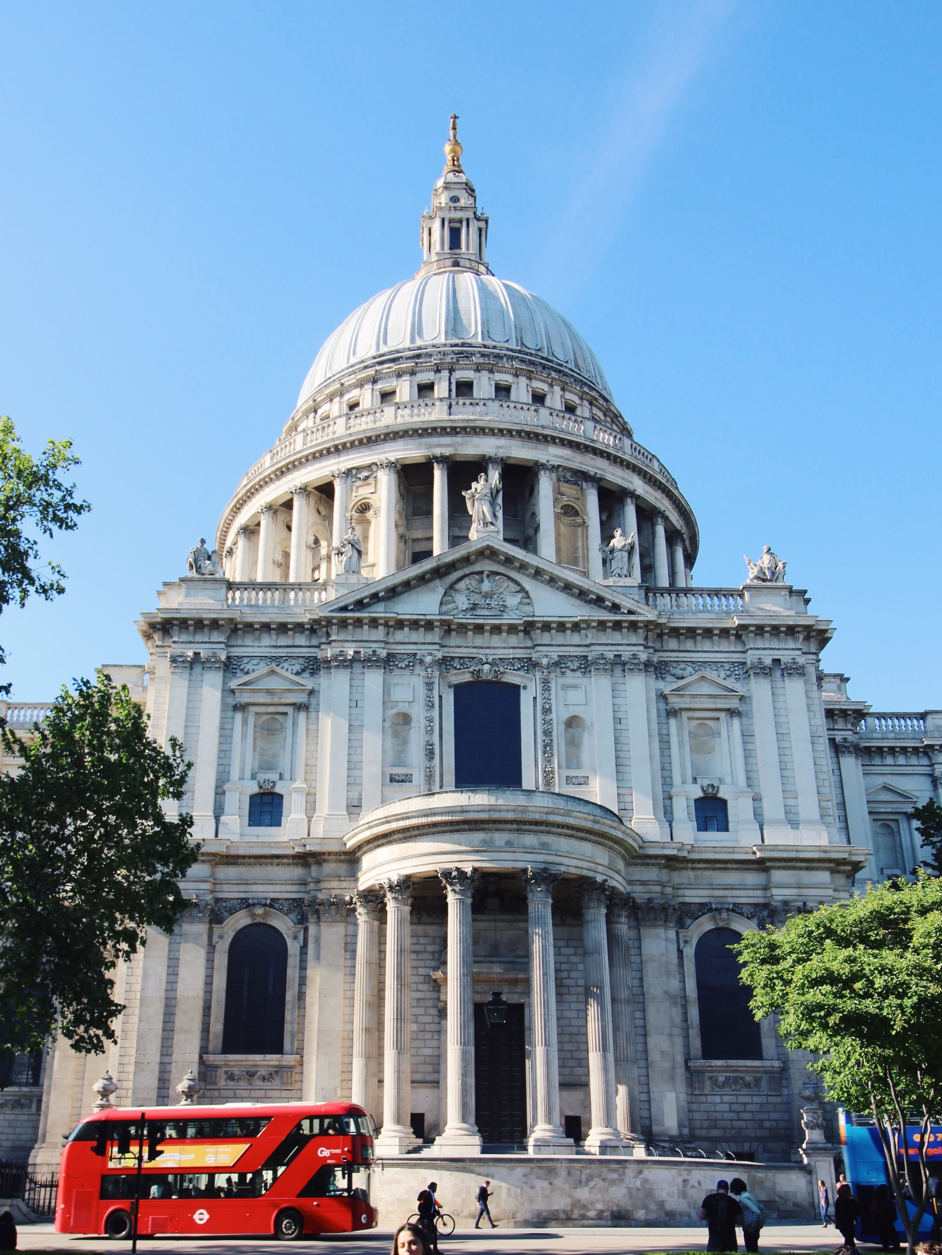 View of the St. Paul's Cathedral with a red tour bus parked in front