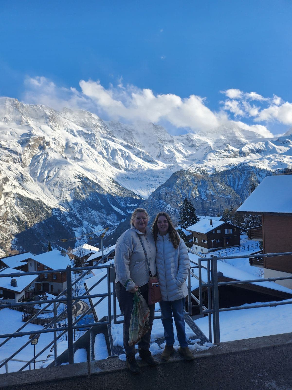 Travel advisor Amy posing with female companion overlooking the snowy mountain village of Murren