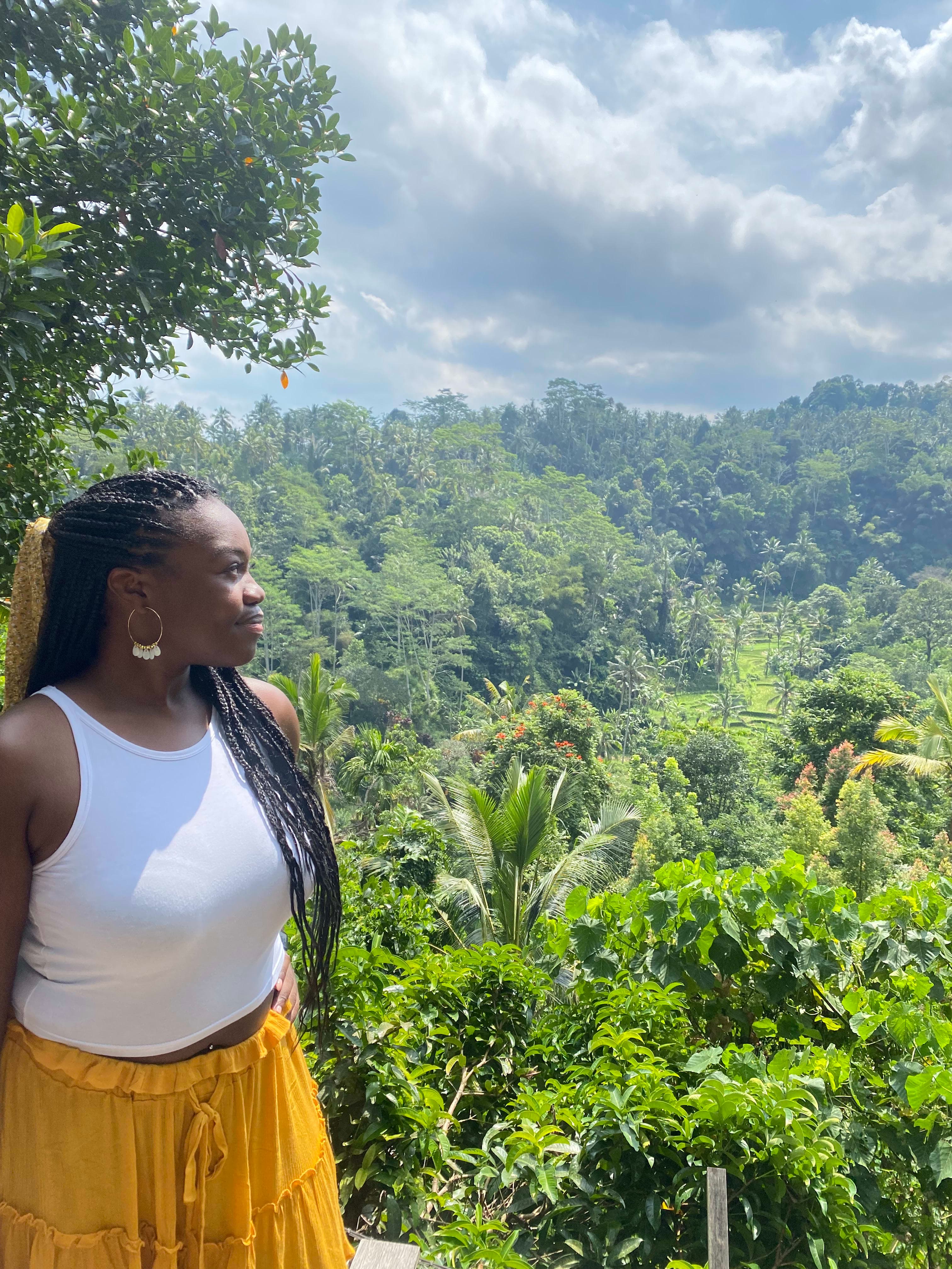 Travel advisor Rondene wearing a white top looking at a beautiful view of a lush forest from above