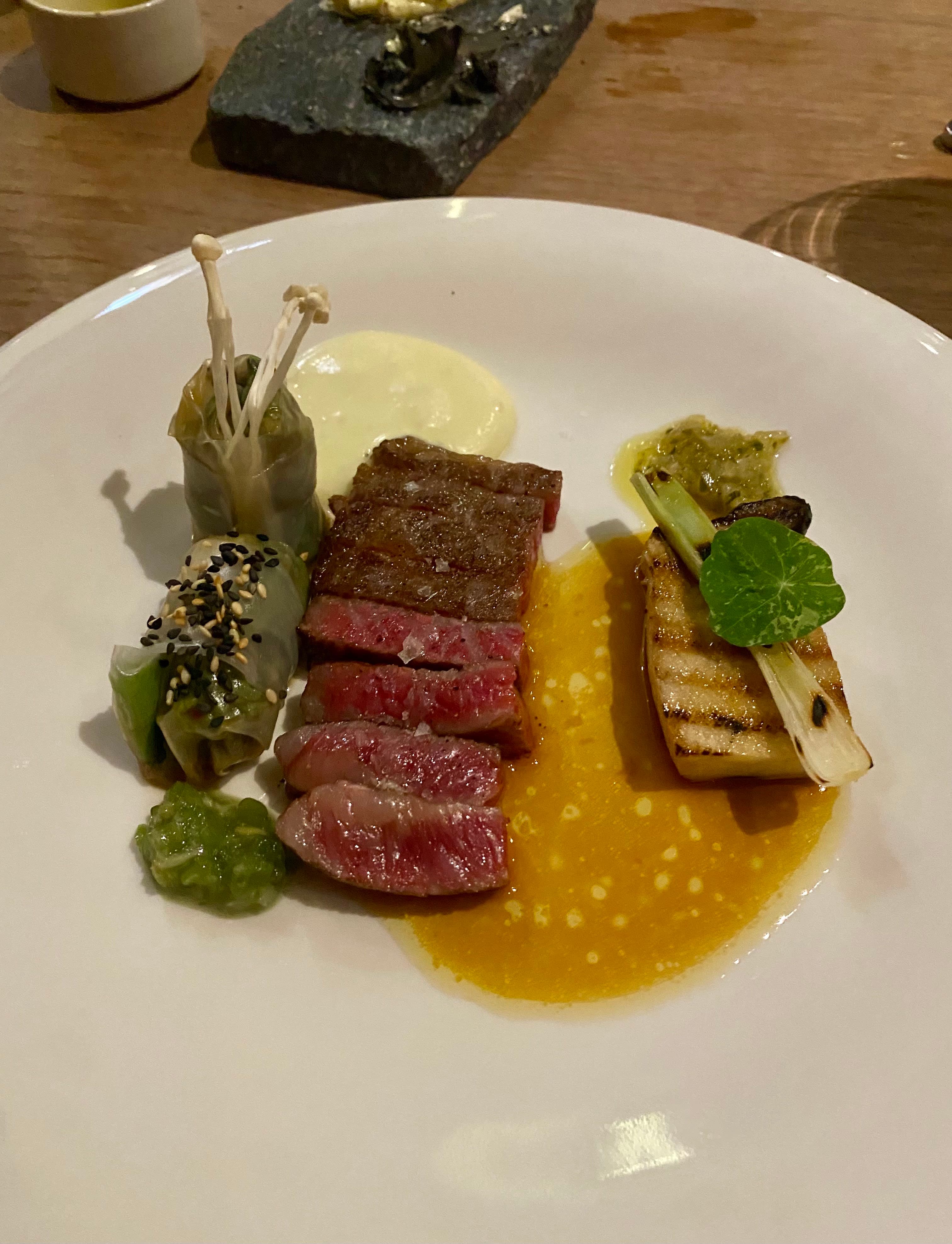 An elegant plate with steak and vegetables at a restaurant