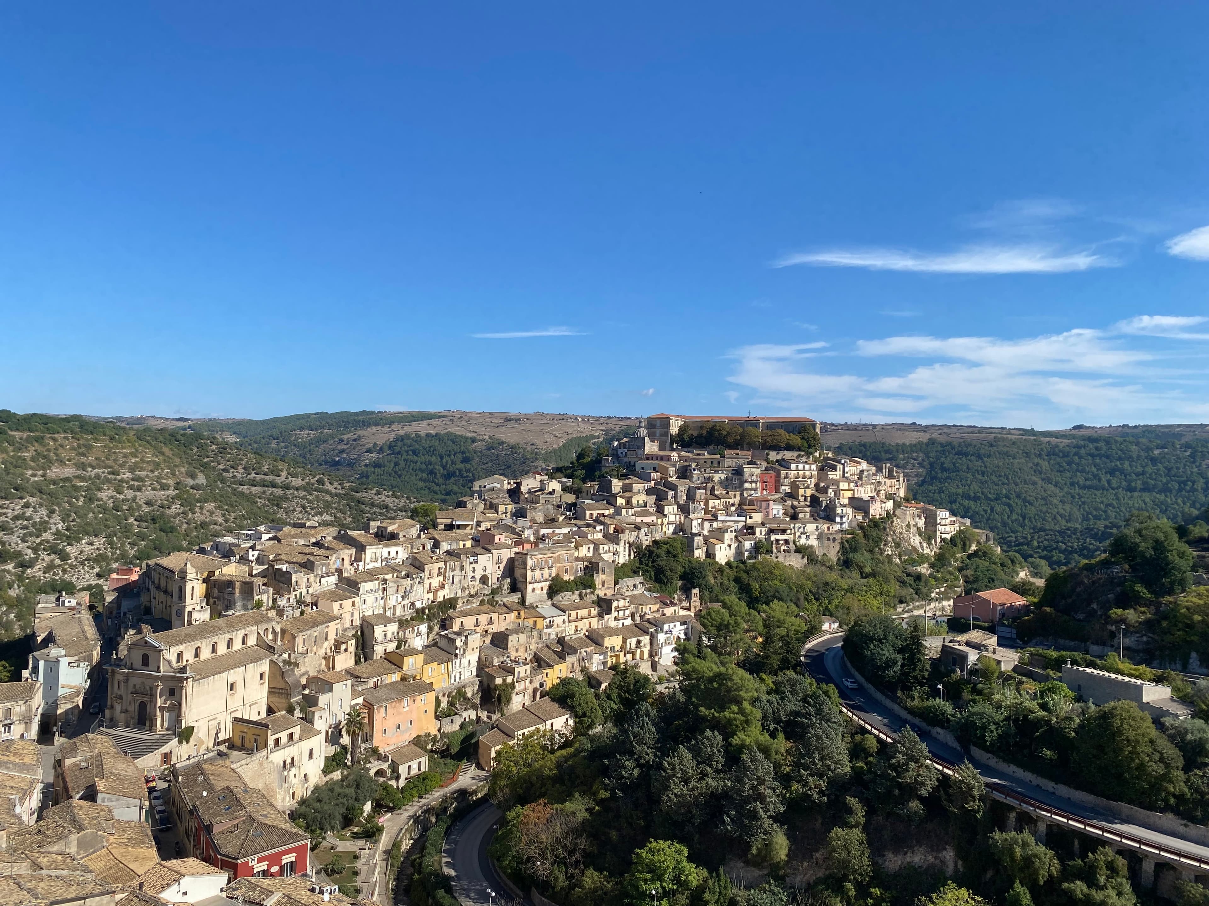 City view of Ragusa, Sicily, from a hilltop, with buildings and trees