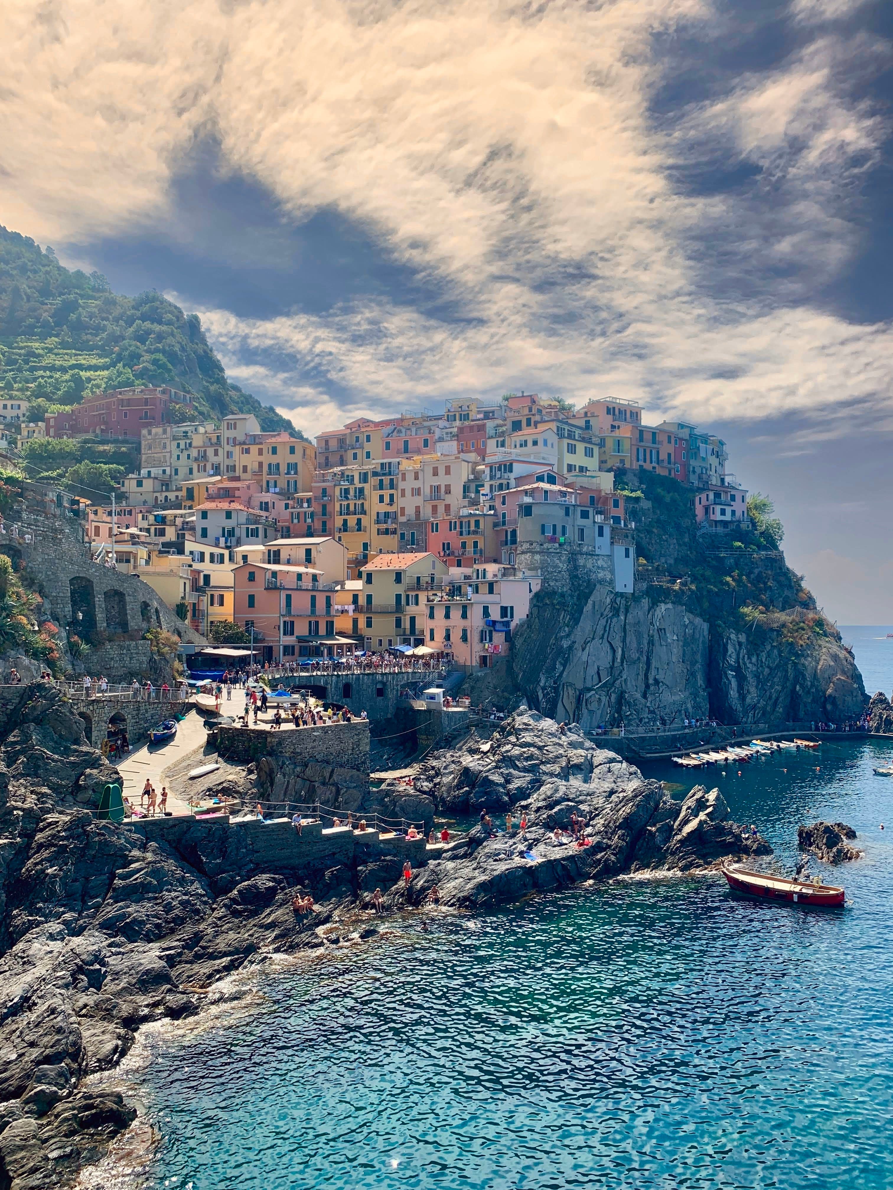 View of the sea and the Cinque Terre coastline. A town full of colorful buildings located on the edge of a cliff.