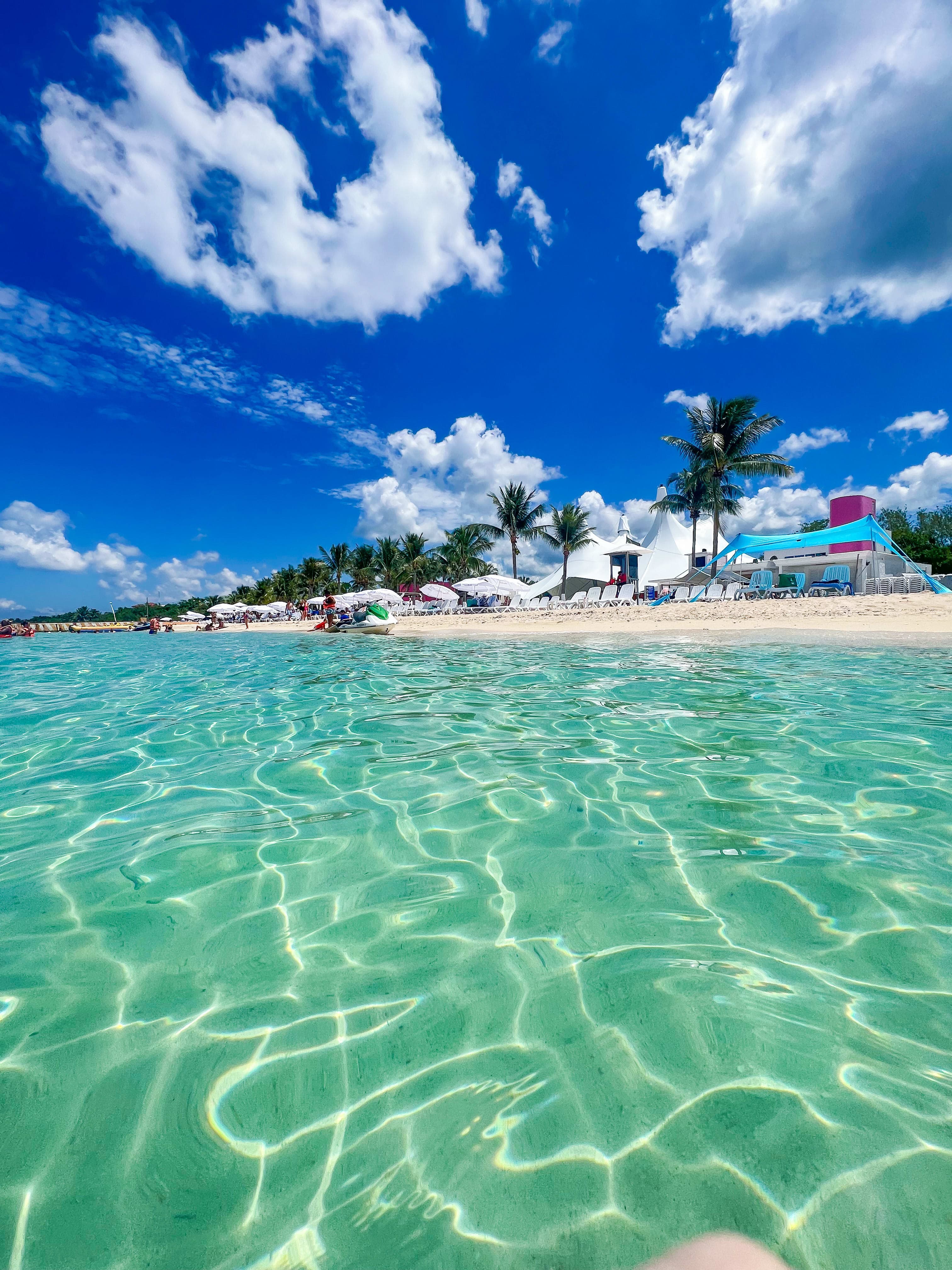 A photo of a beach club from the crystal clear water on a bright sunny day.