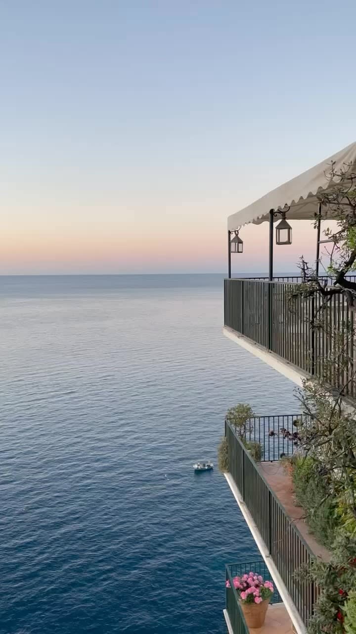 A hotel balcony overlooking the ocean at sunset