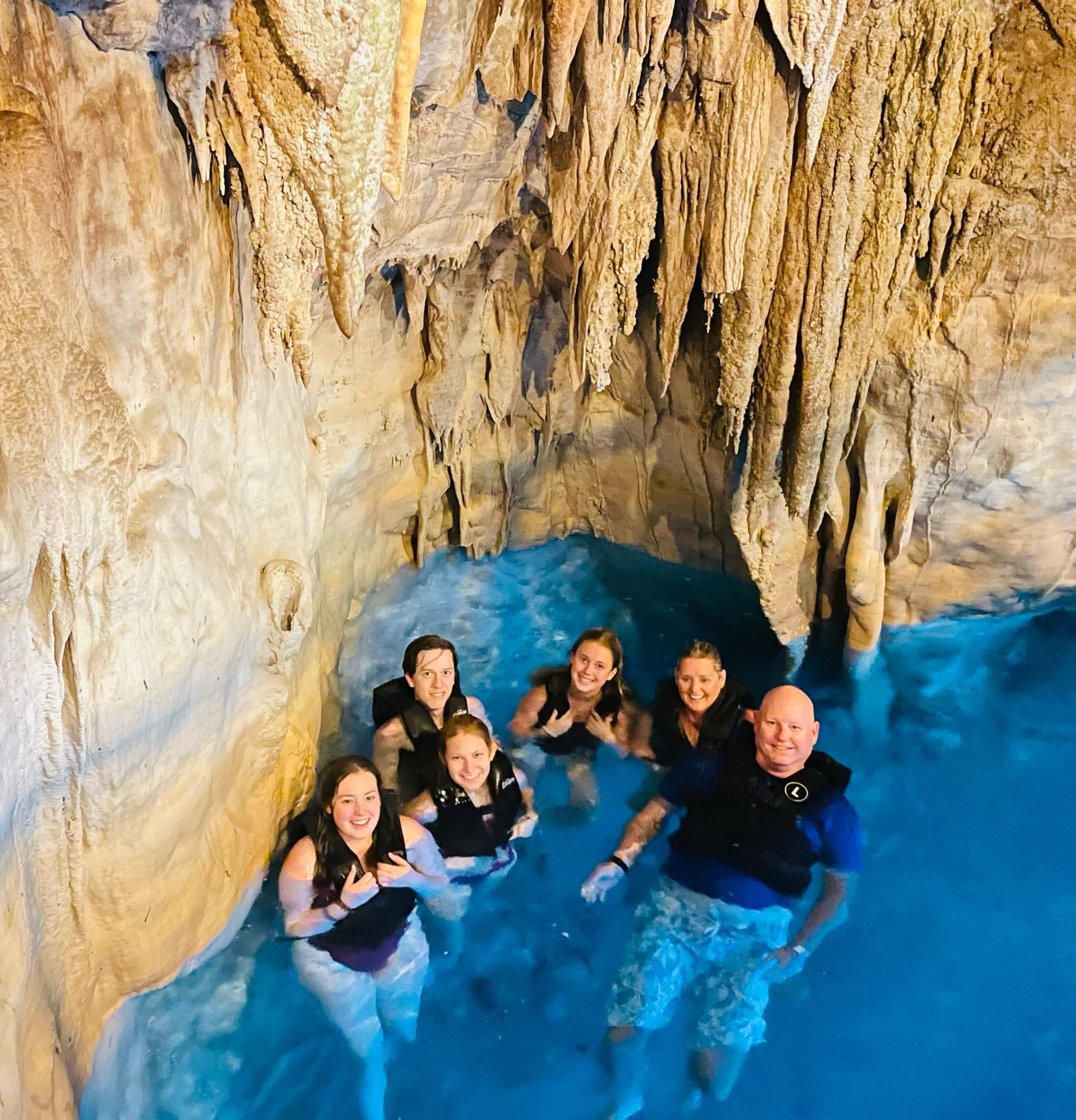 A family posing for a photo while swimming in a cave