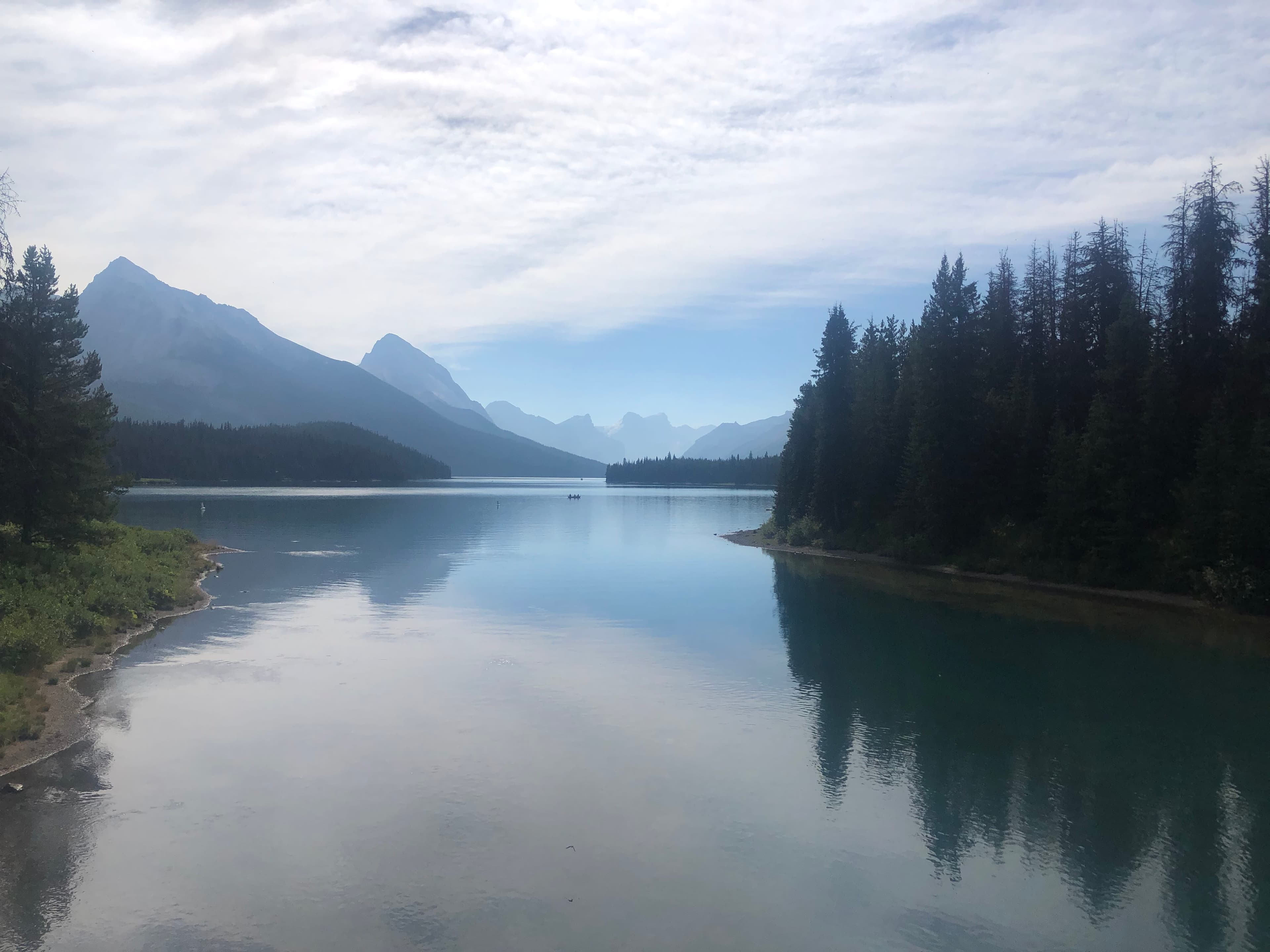 Beautiful view of calm lake with trees and mountains on both sides