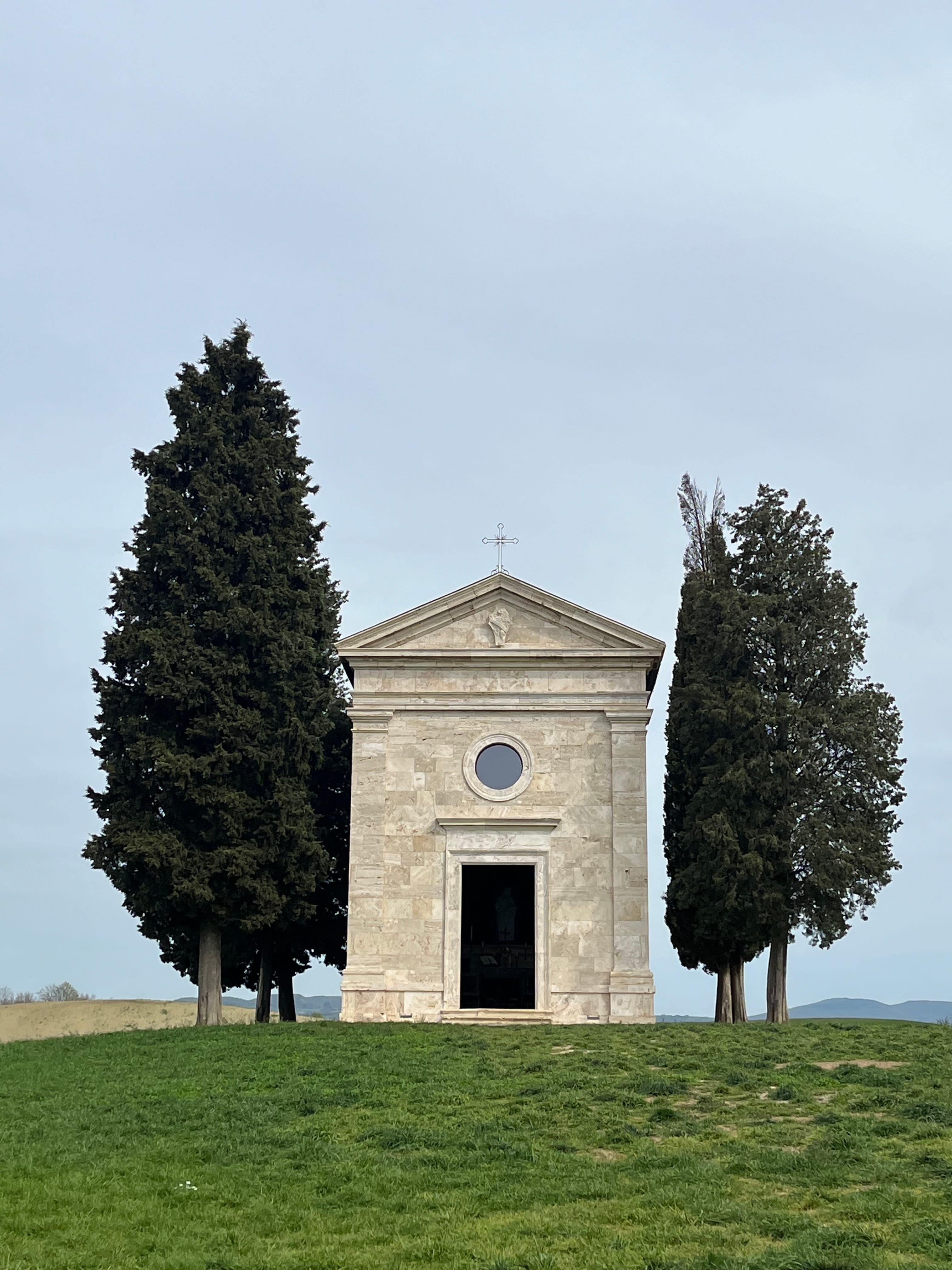 Beautiful view of Chapel Vitaleta in between two tall trees