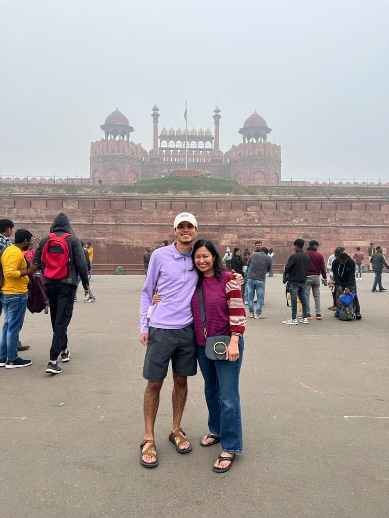 Travel advisor Jackson and female companion standing in a large square in front of an impressive red-colored building