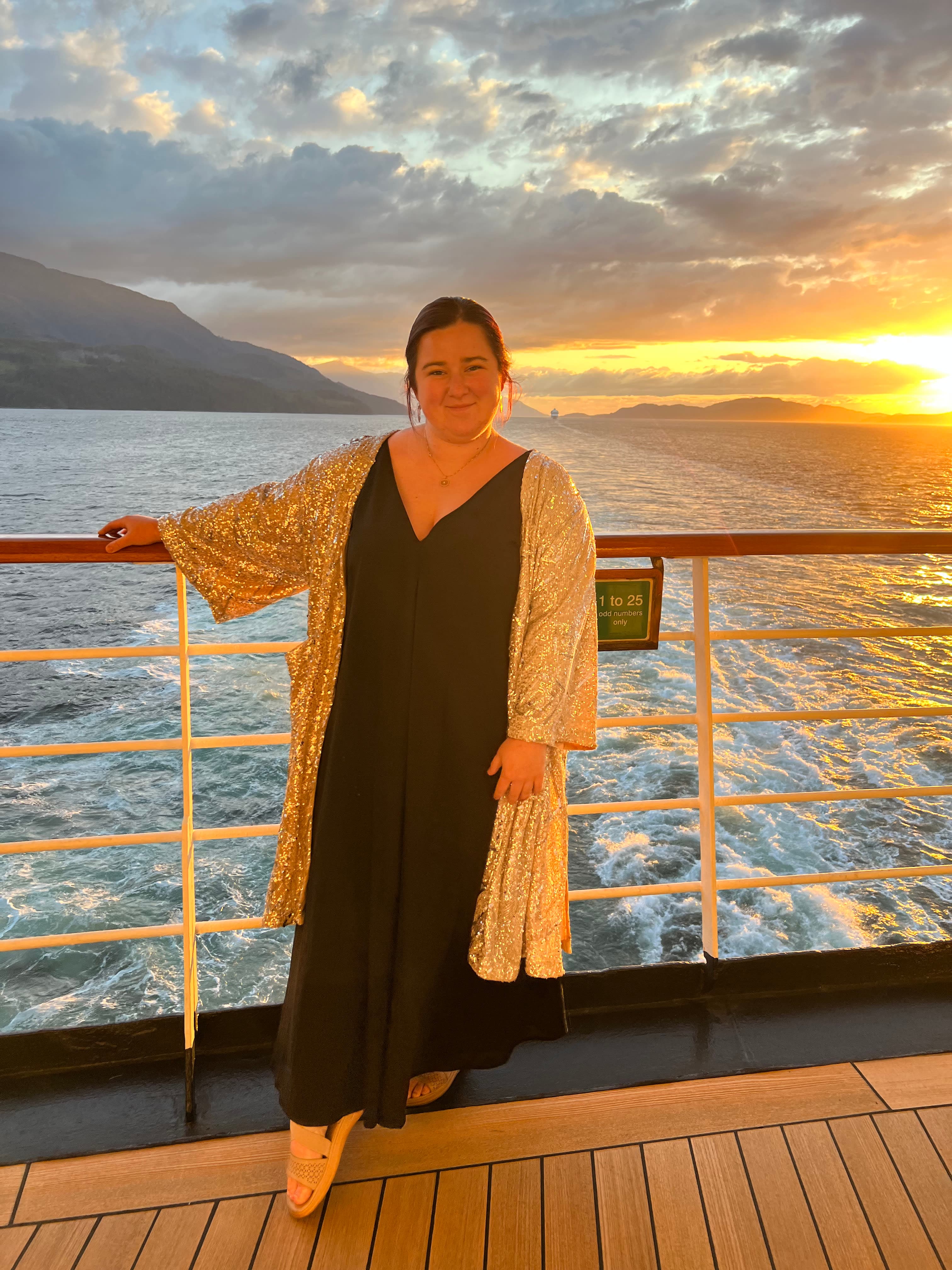 Erika standing on the boat deck enjoying the view of sunset