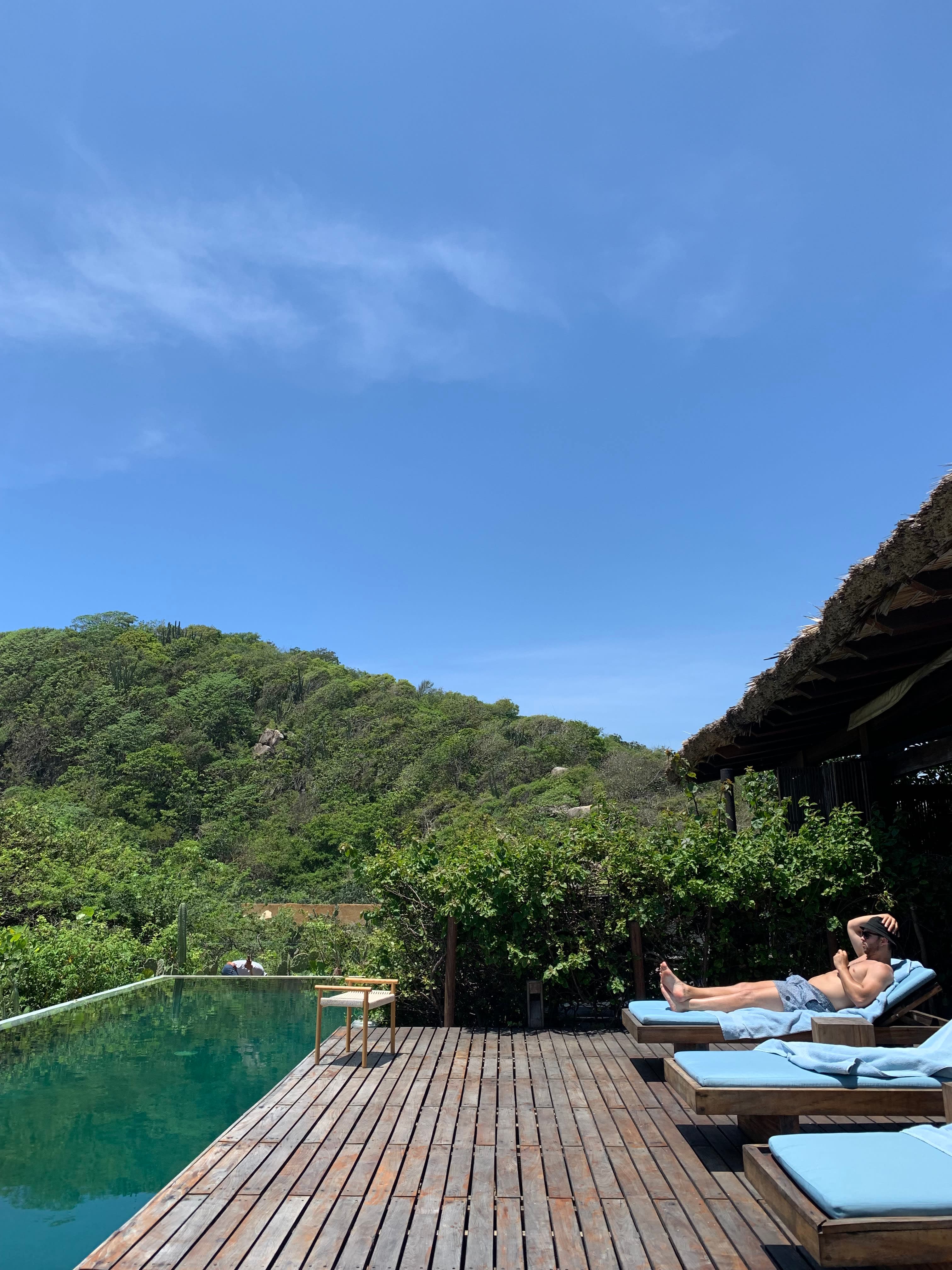 Picture of a man sitting on sunloungers beside the pool
