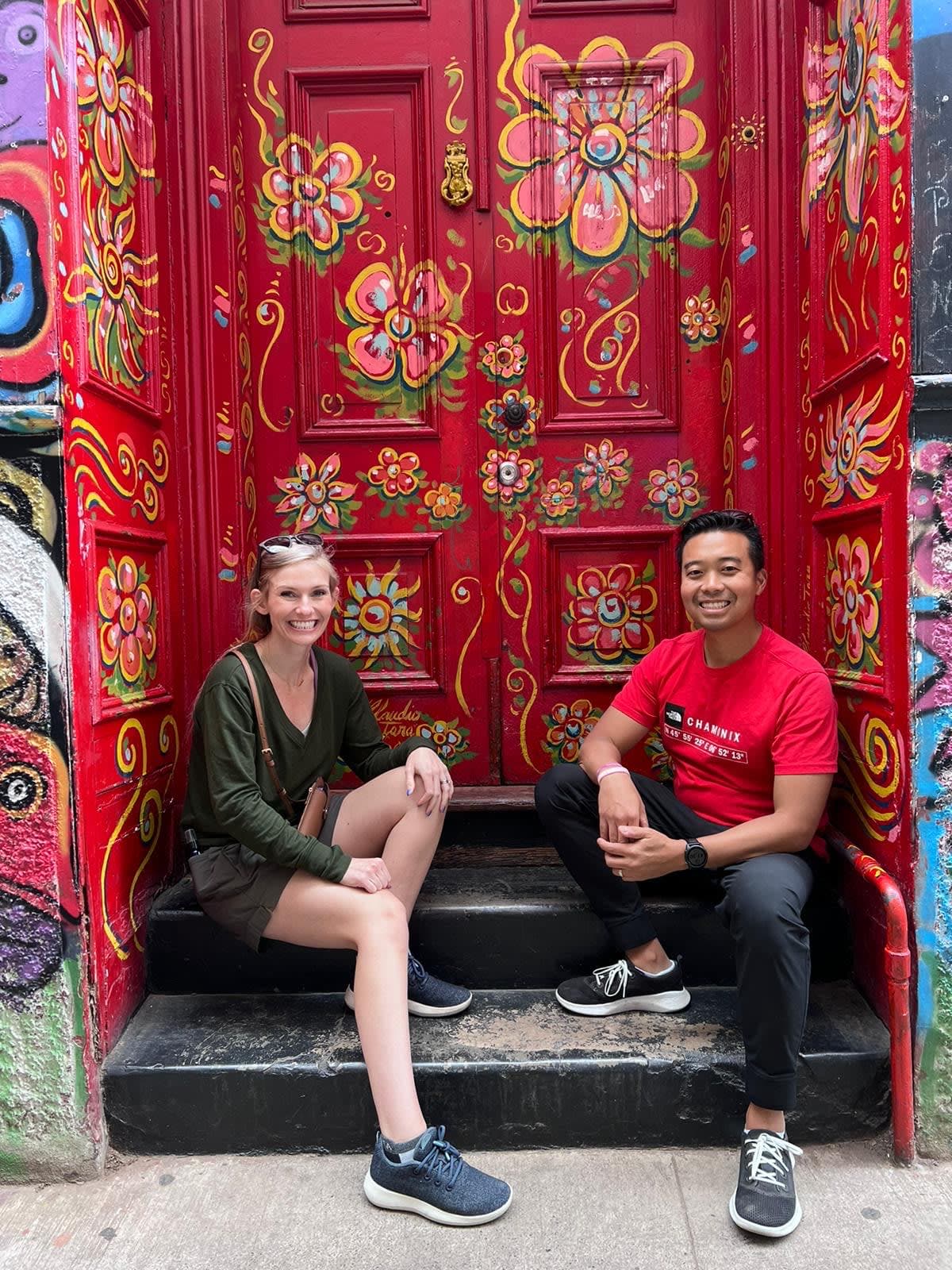 Picture of Loni sitting outside a flower painted door