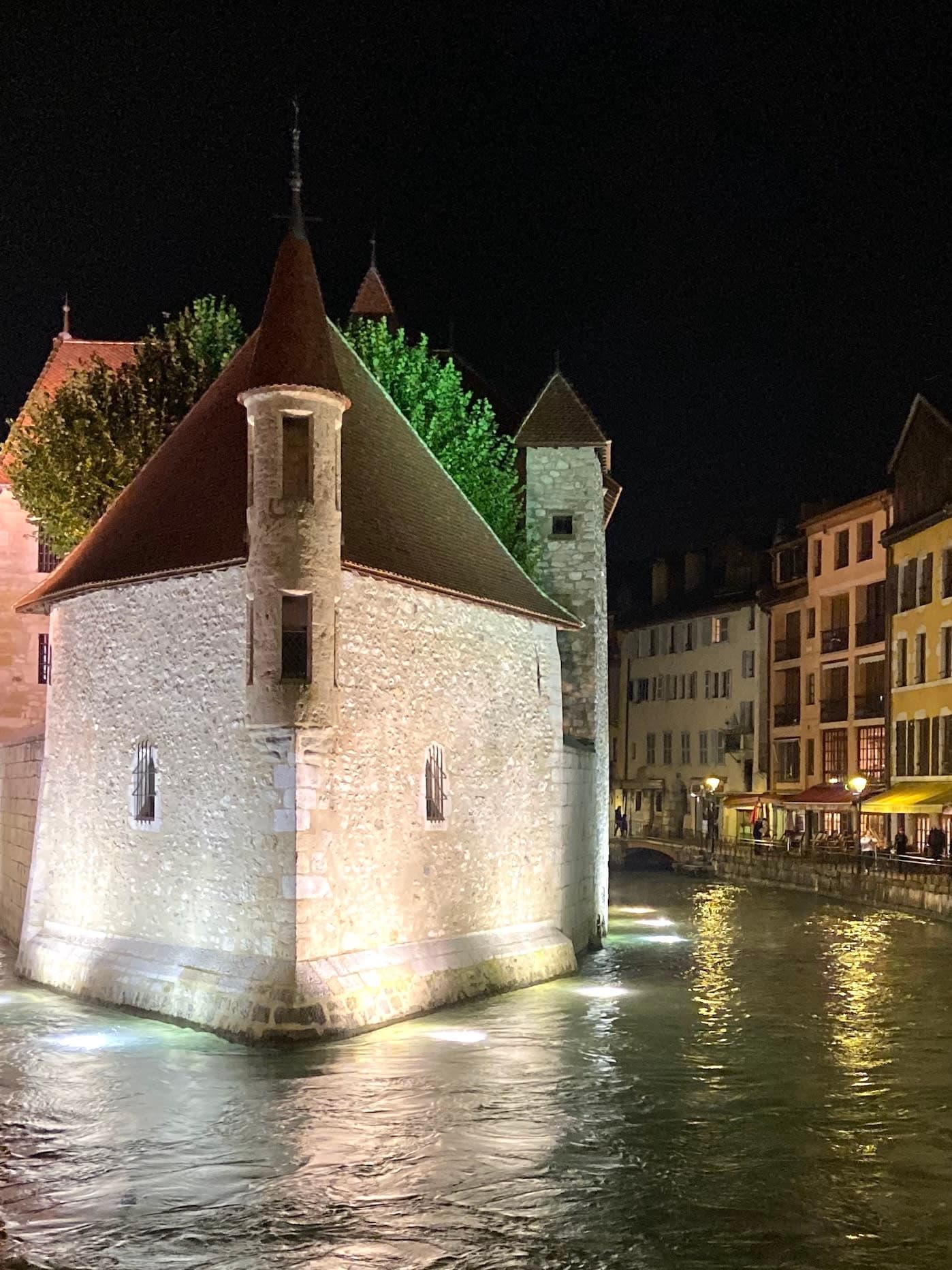 View of Le Palais de I'Île museum in Annecy, France at night