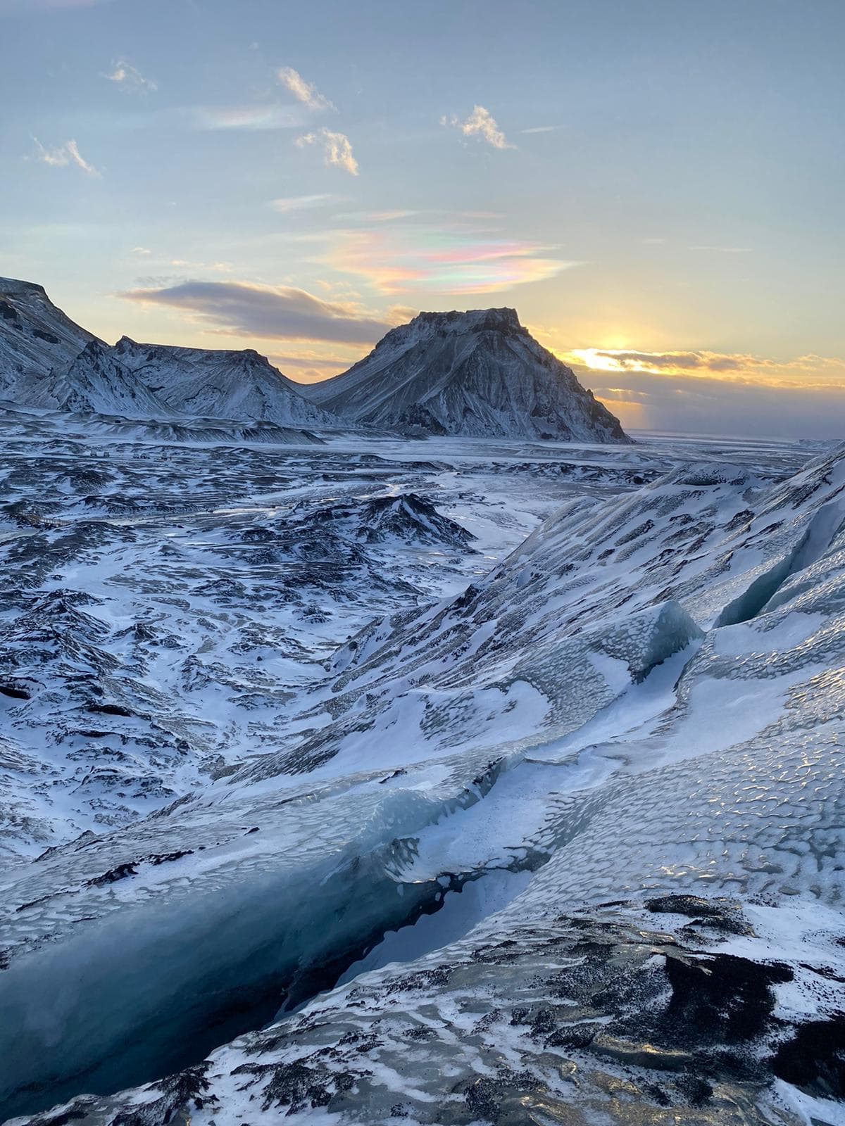 A rocky valley covered in snow at sunrise.
