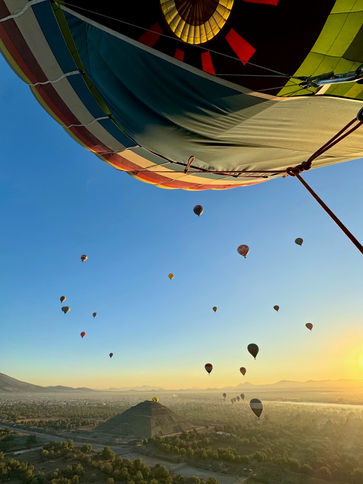 A sky filled with hot air balloons taken from another hot air balloon.