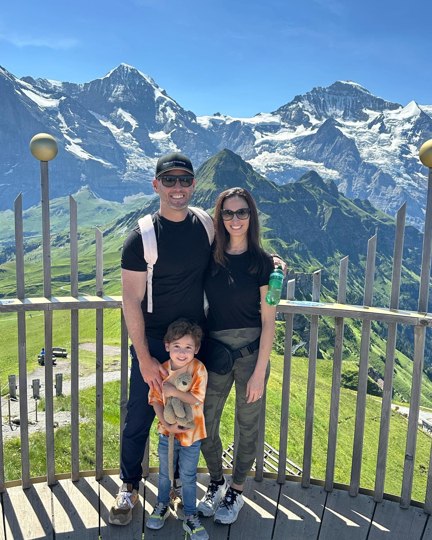 Picture of Mindy posing with family in front of beautiful snow-capped mountains on a sunny day