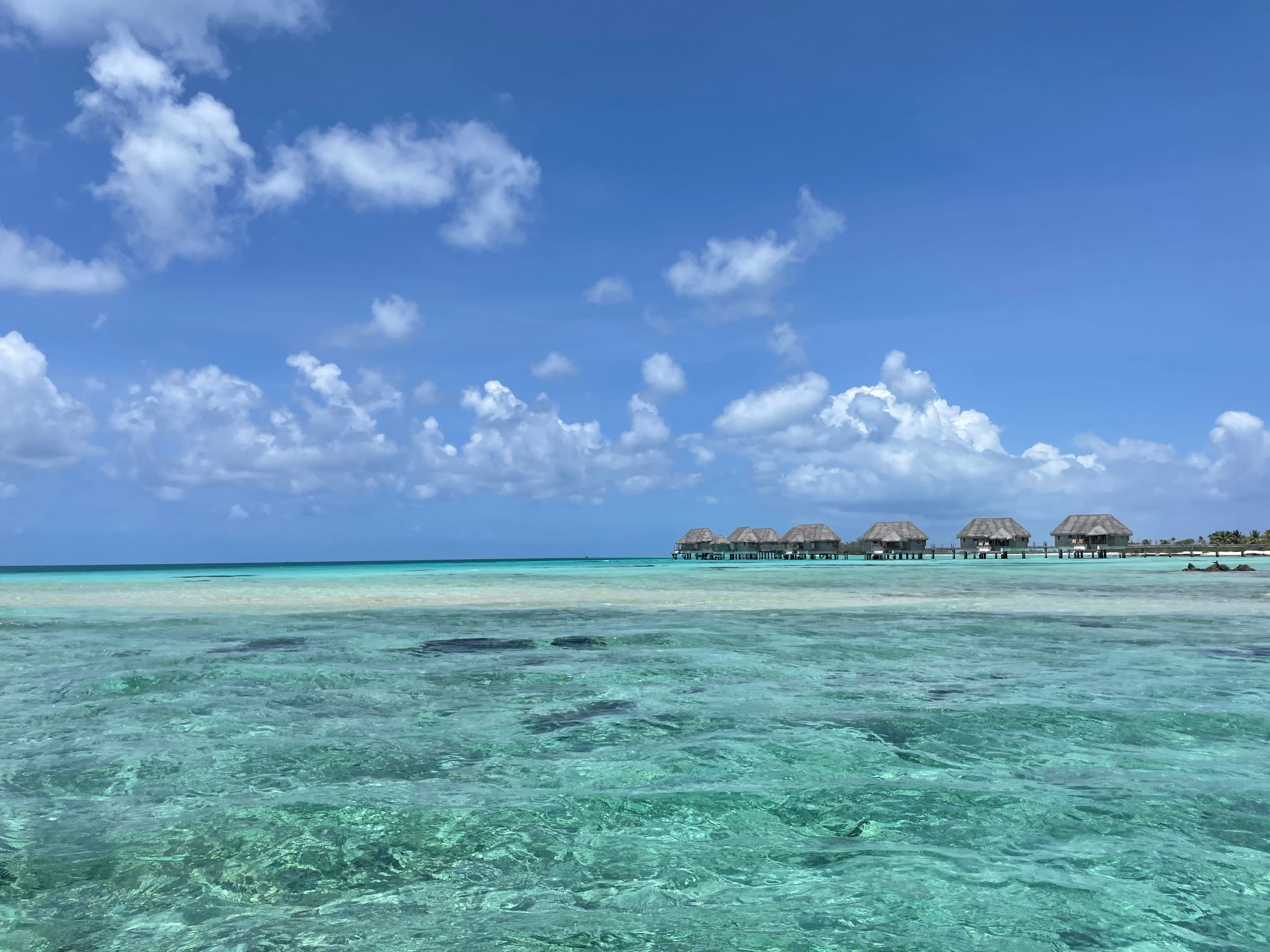 Beautiful clear blue water of the sea and view of water lodges in a distance