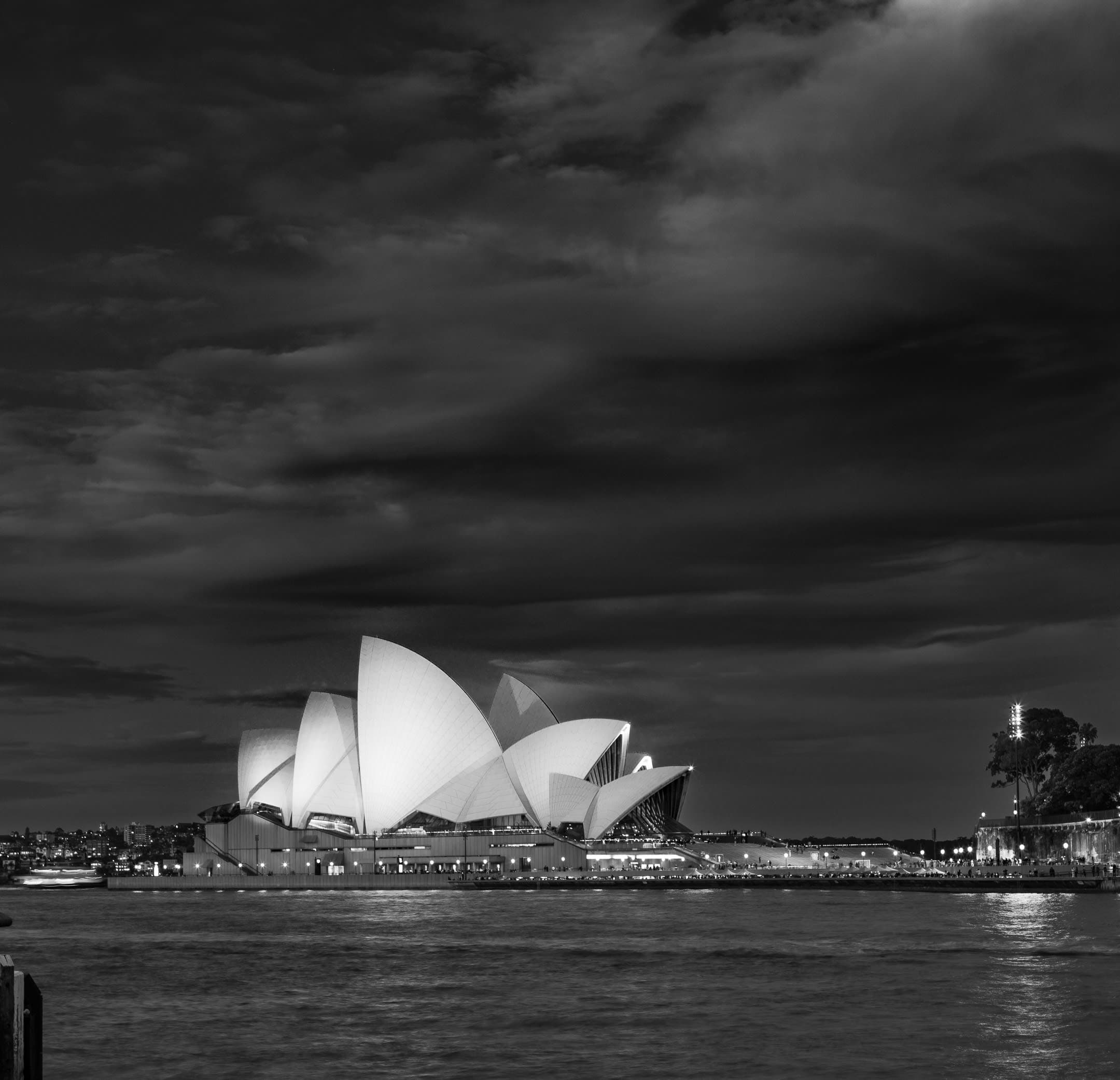 A grey scale image of the Sydney Opera House on a cloudy night
