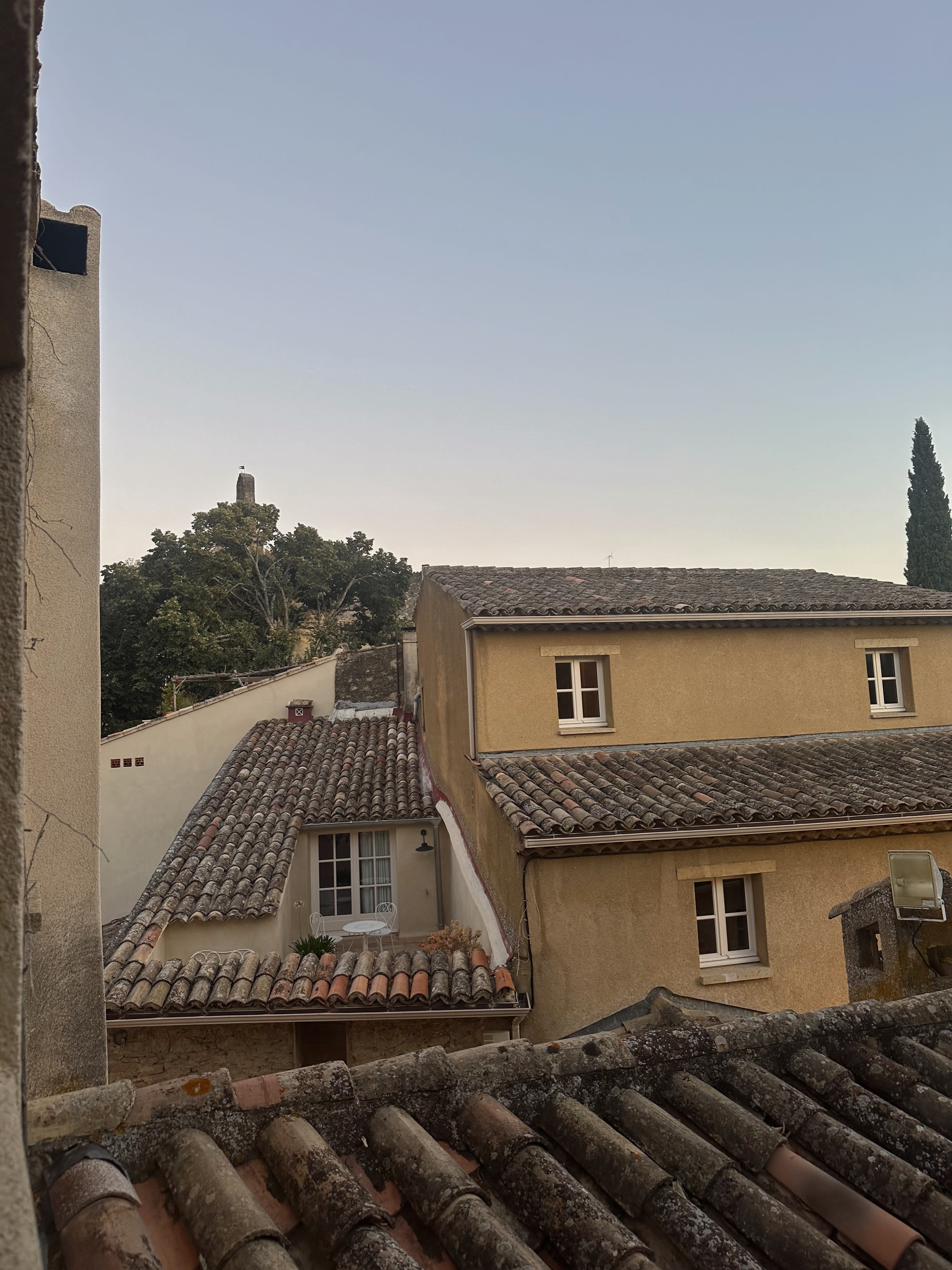 Photo taken from the window of a hotel with the view of rooftops and windows of neighboring buildings.