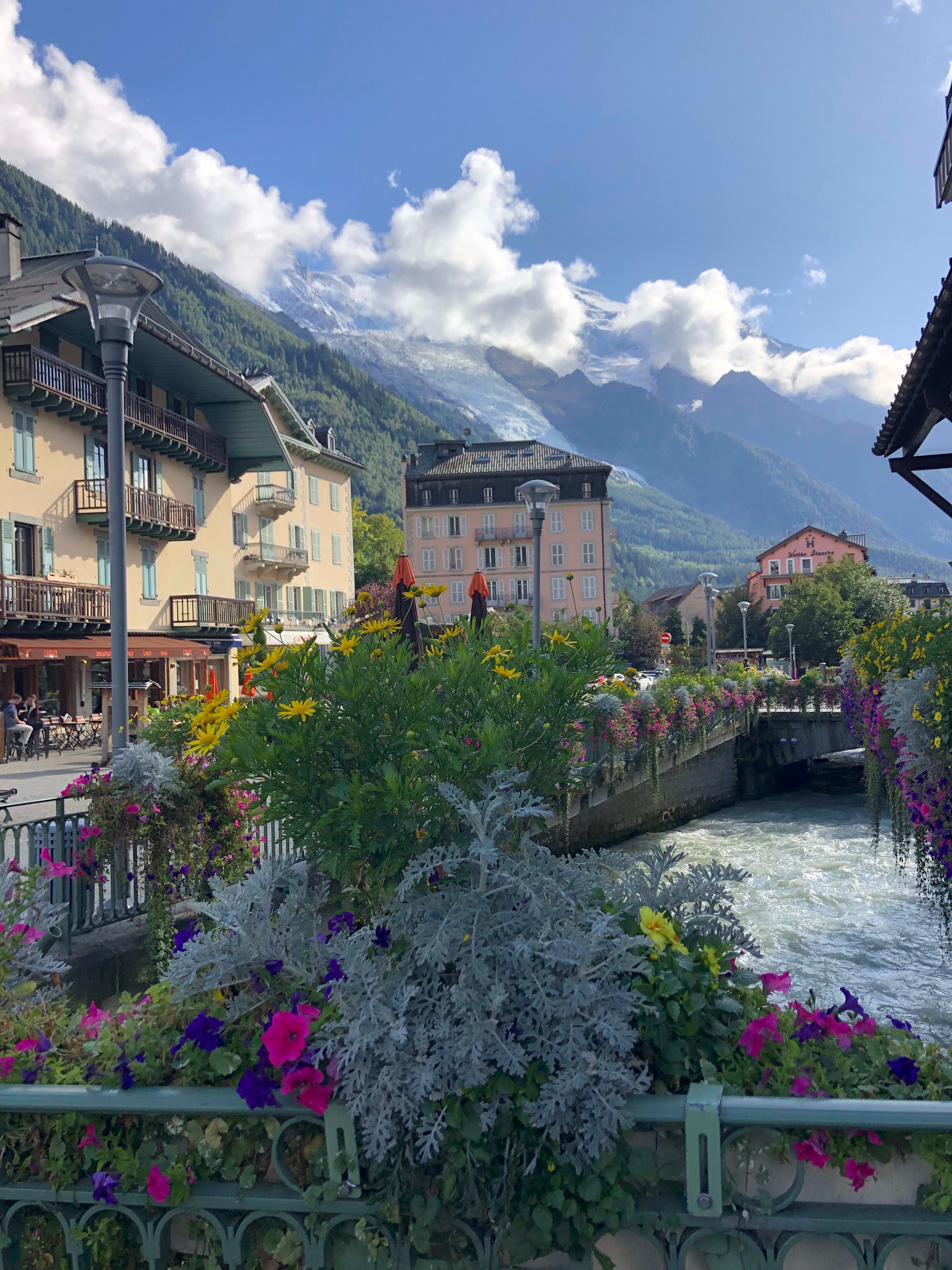 Beautiful view of a town with colorful buildings and a small river with mountains in the distance