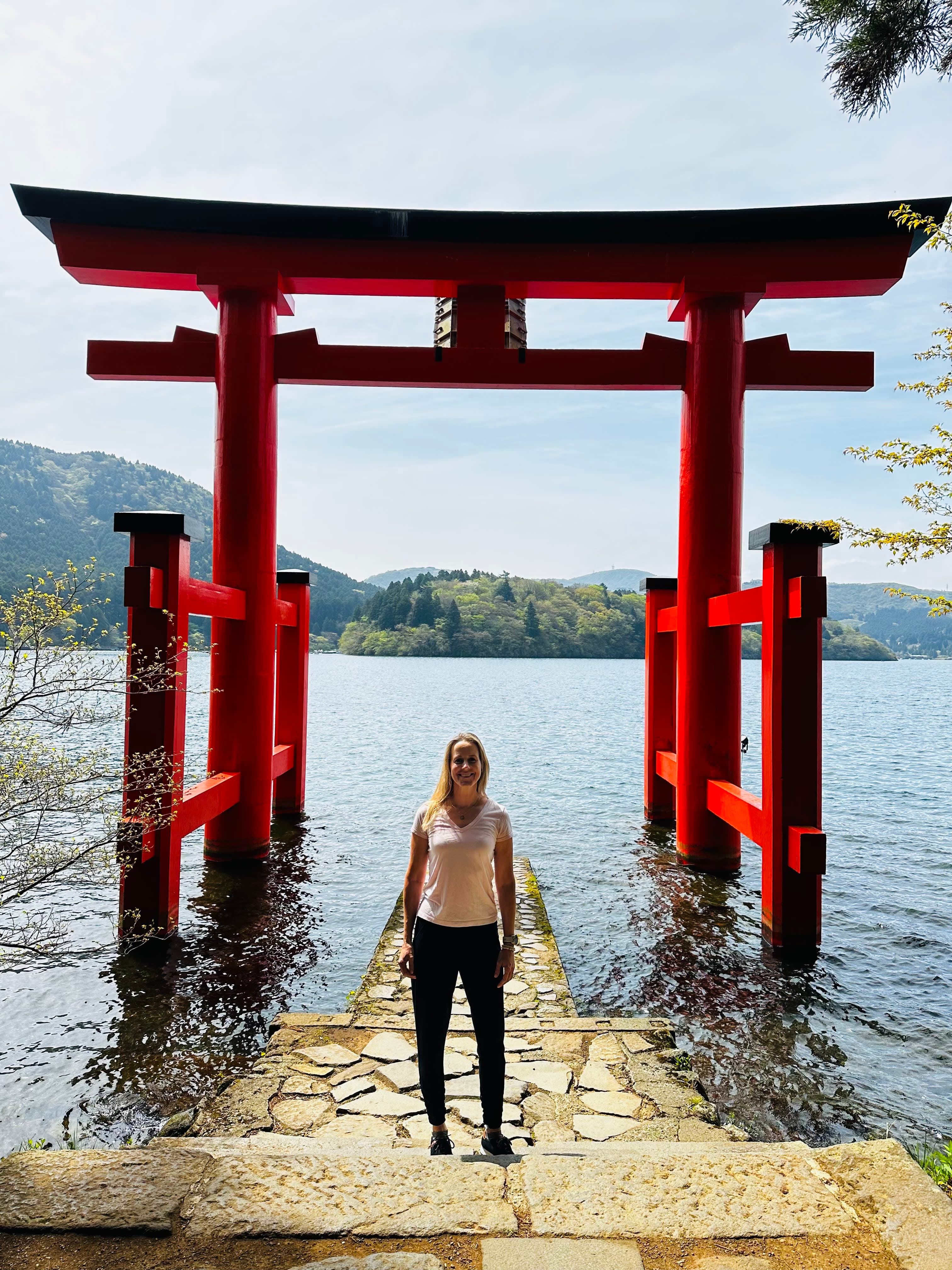 erika standing underneath a red archway in front of a lake