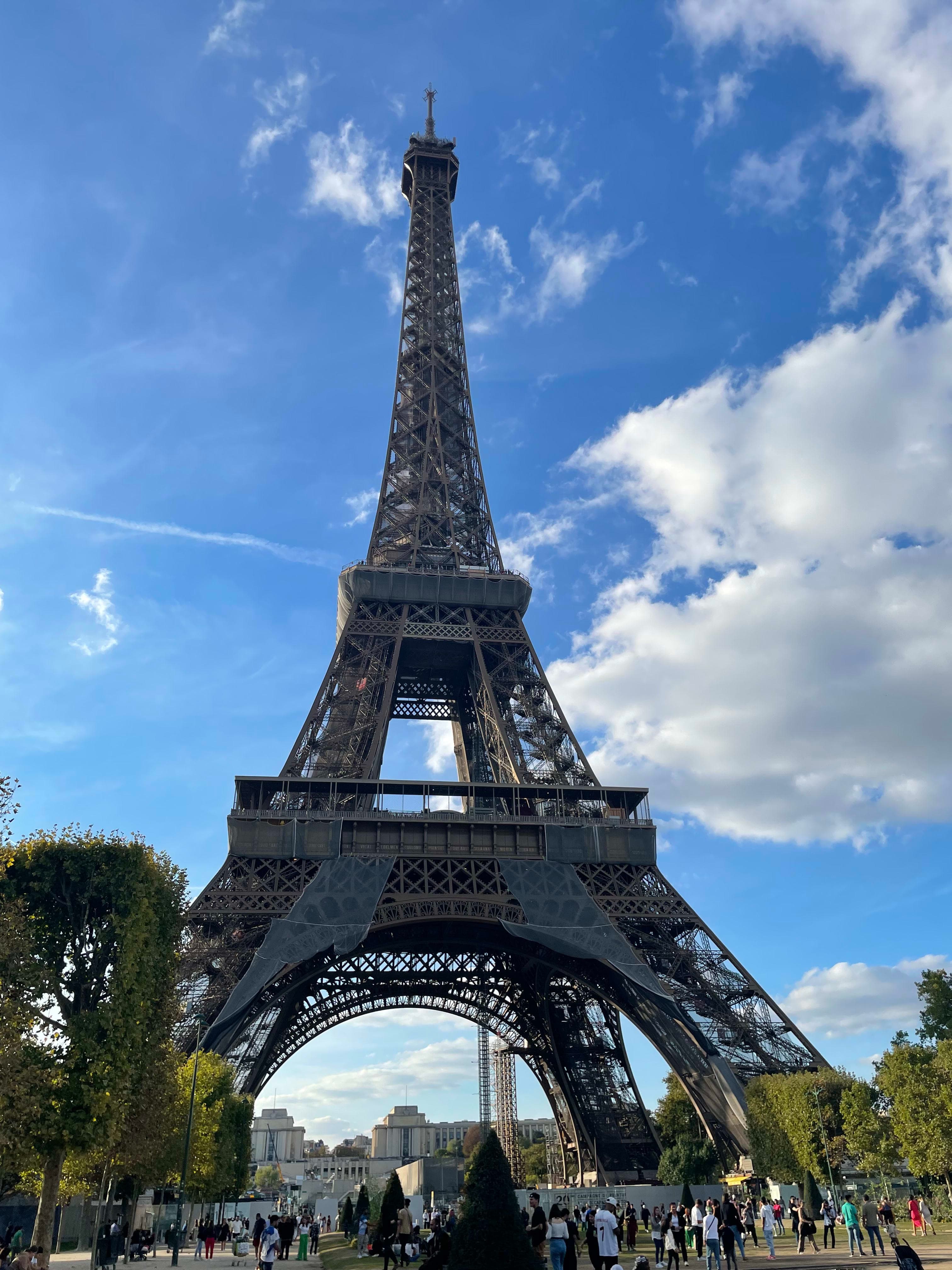 the Eiffel Tower with a blue sky and clouds in the background