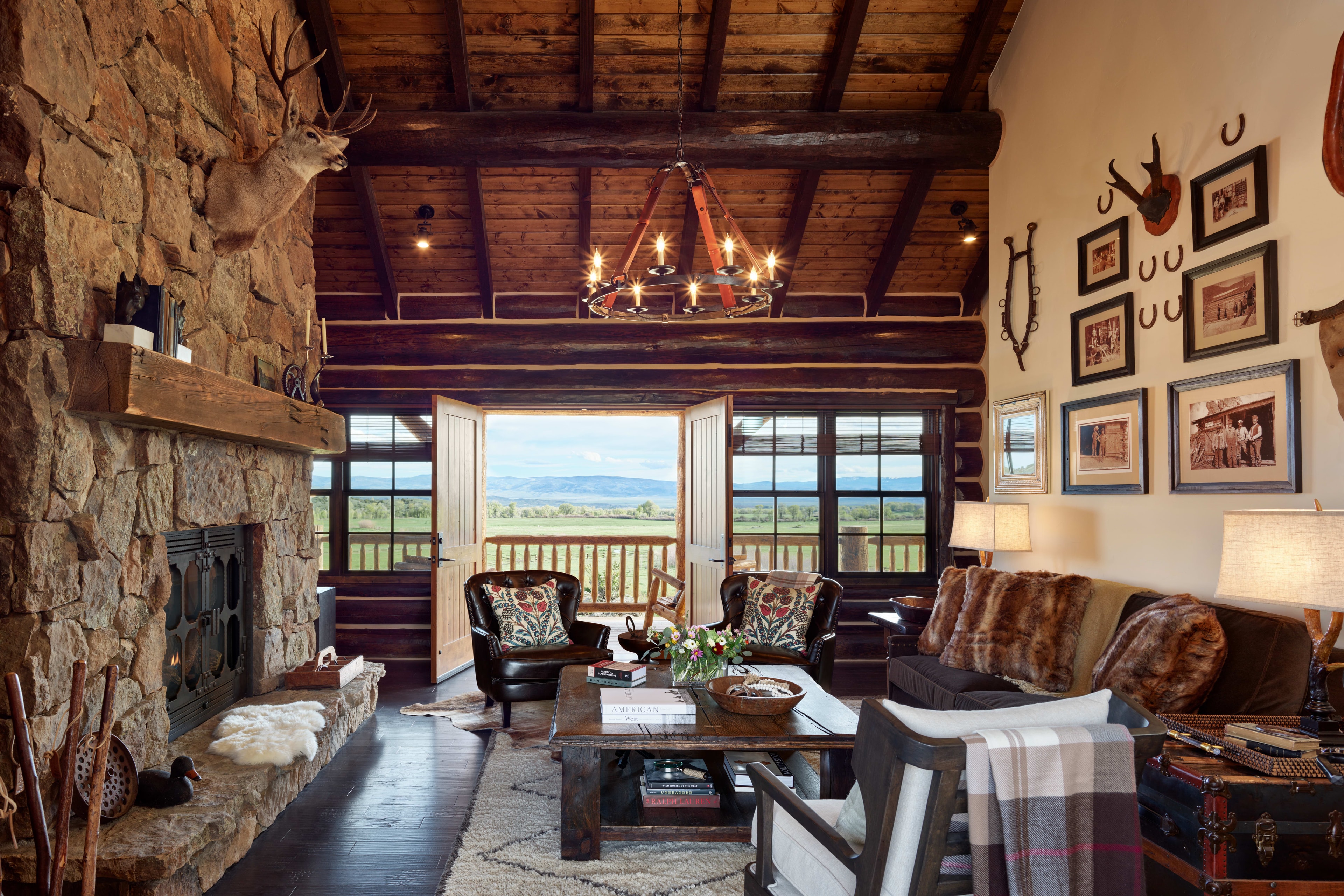 a cozy Western cabin with a stone fire place and leather furniture