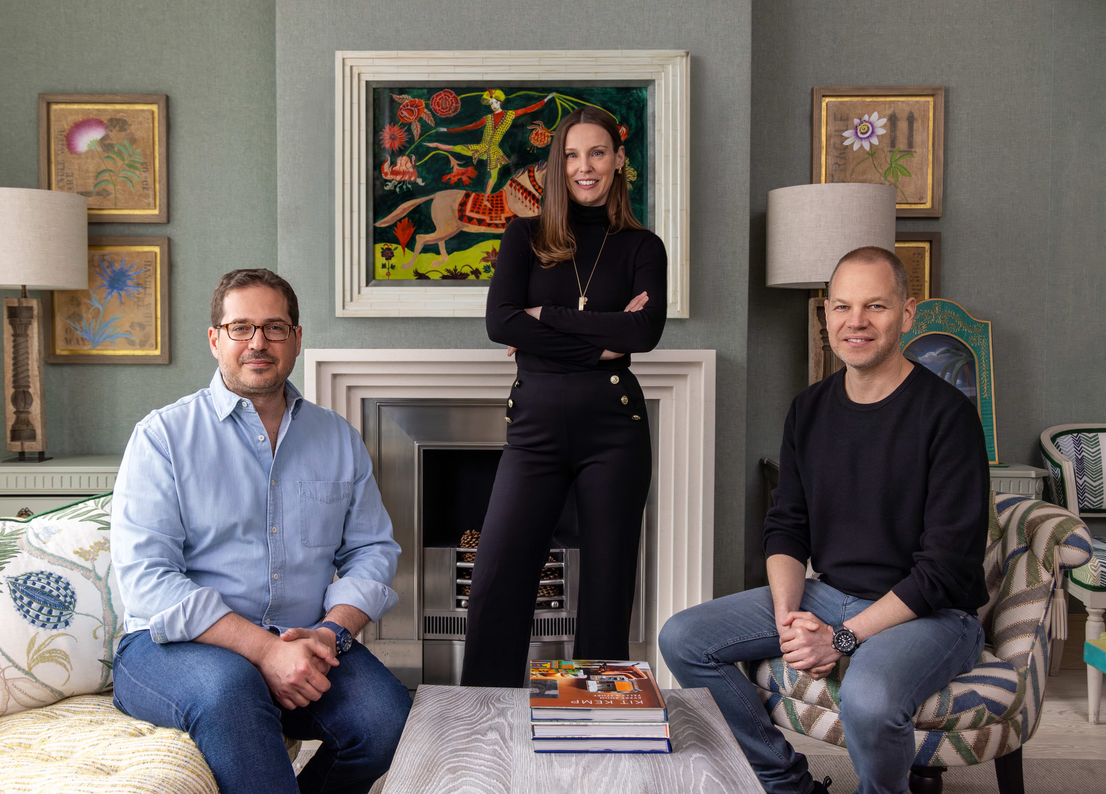 two men and a woman smile together outside on a sunny day
