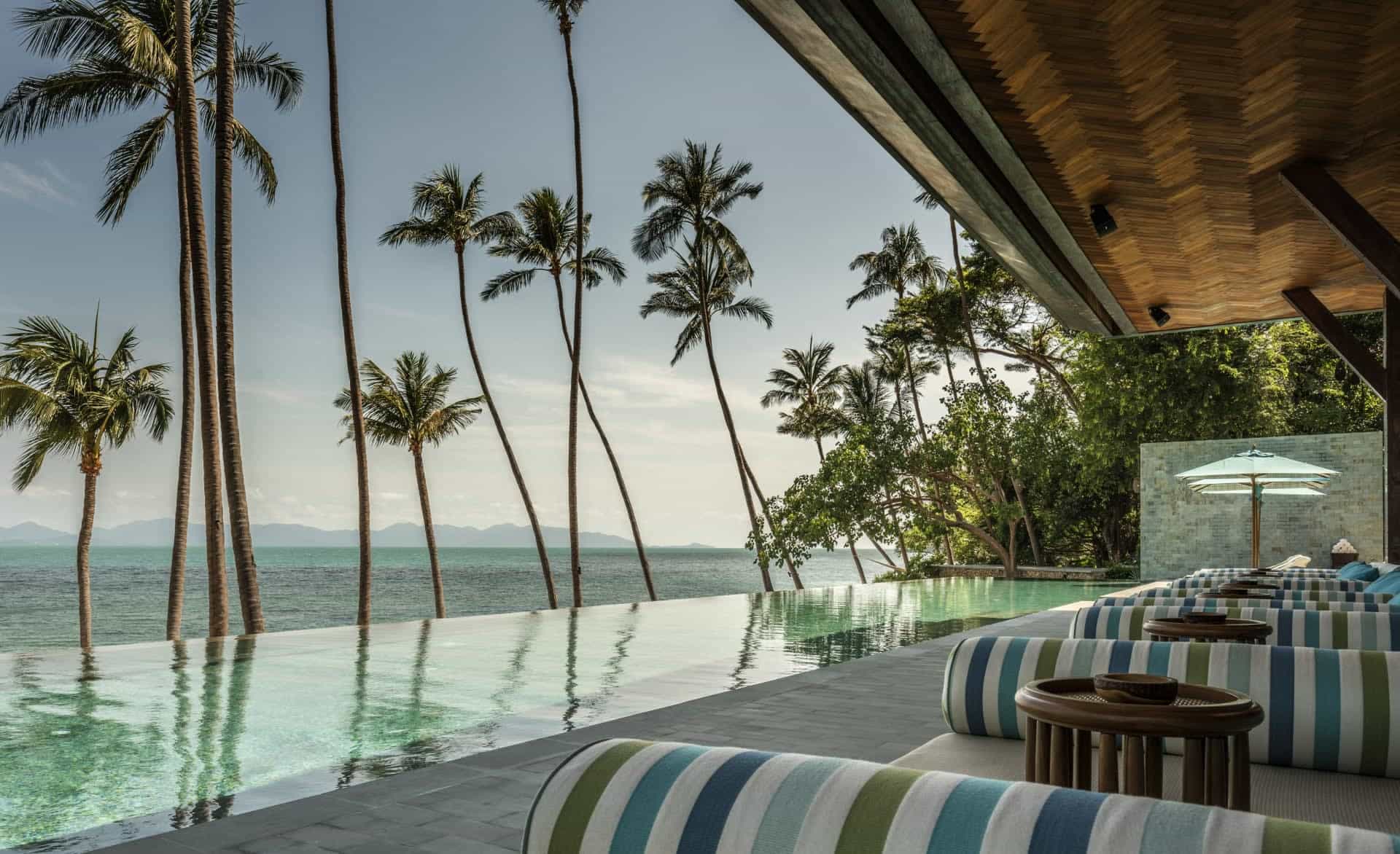 10 Instagram-Worthy Hotel Pools to Visit in 2026 View of an infinity pool with palm trees and ocean beyond