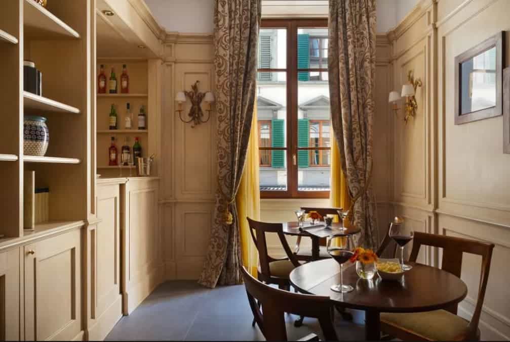 Insider Picks for Hotels under $500 in Florence Two round dining tables in a cozy room with large windows and patterned drapes