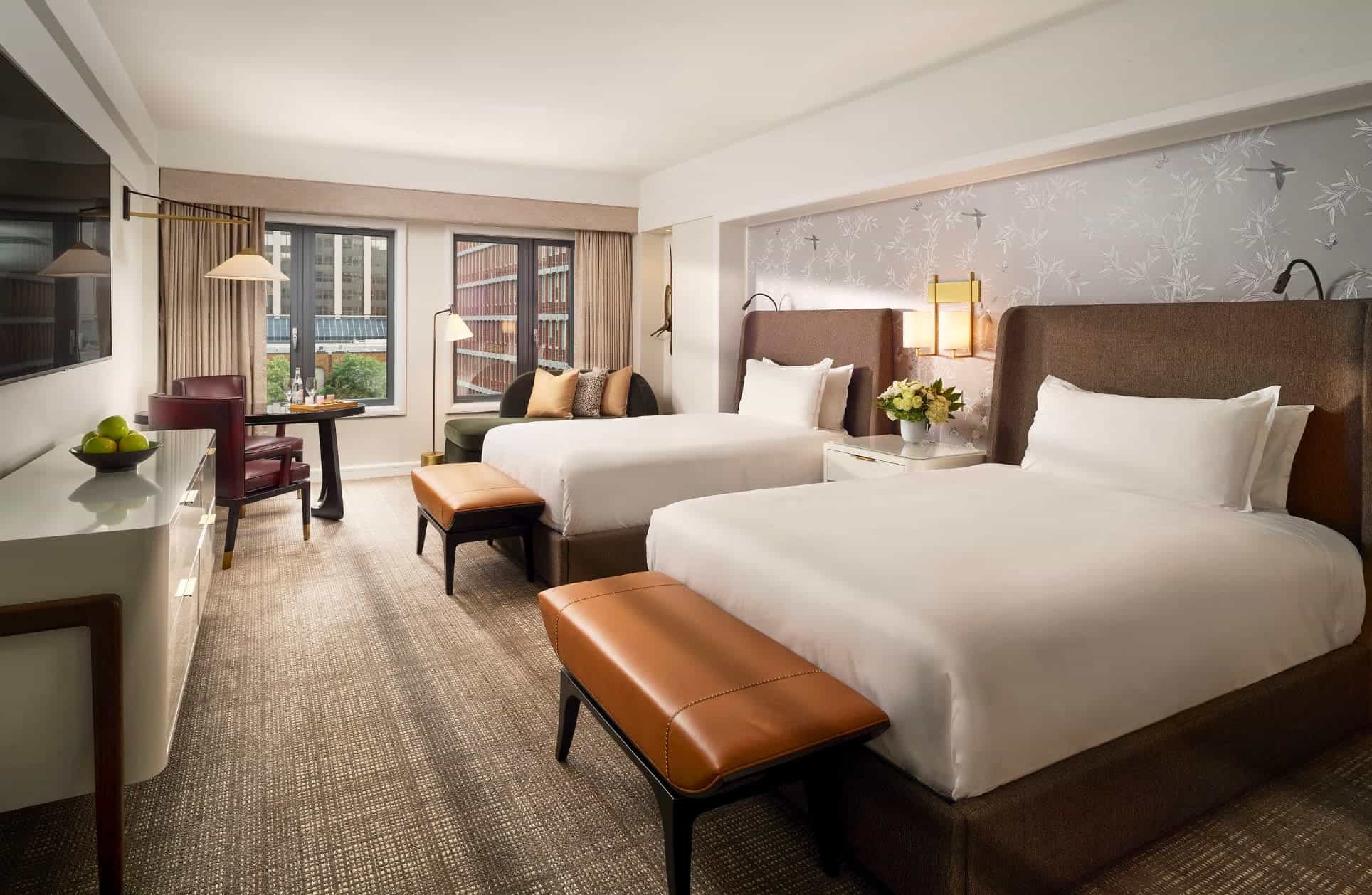 a hotel room with two double beds and sleek modern furnishings