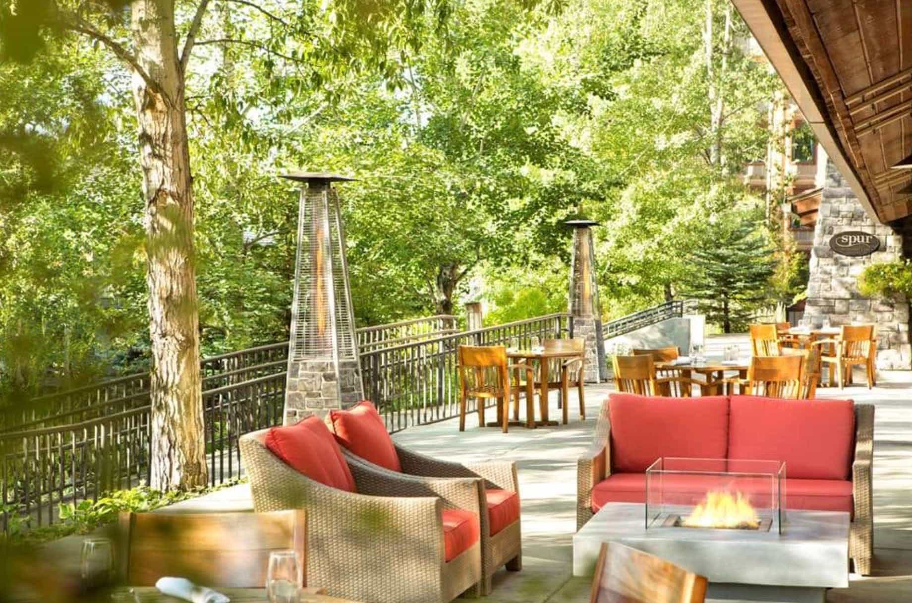 shaded patio with red and wicker seating and fire pit
