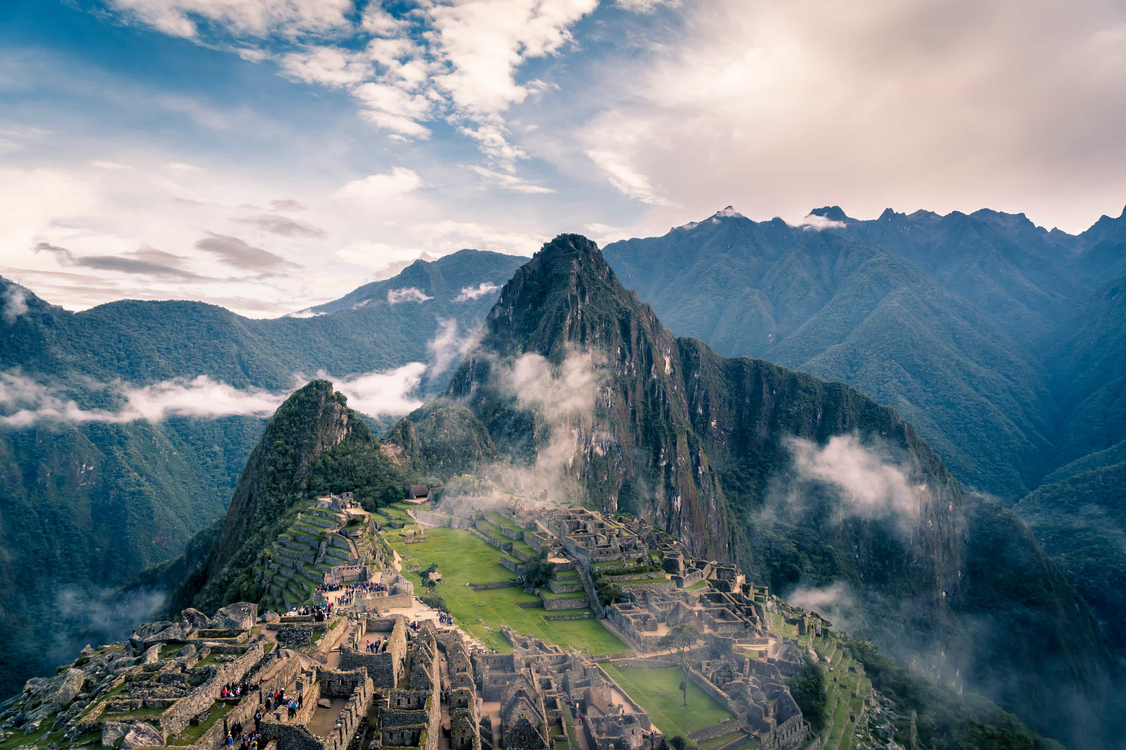 mountain with clouds during day and mountaintop ruins