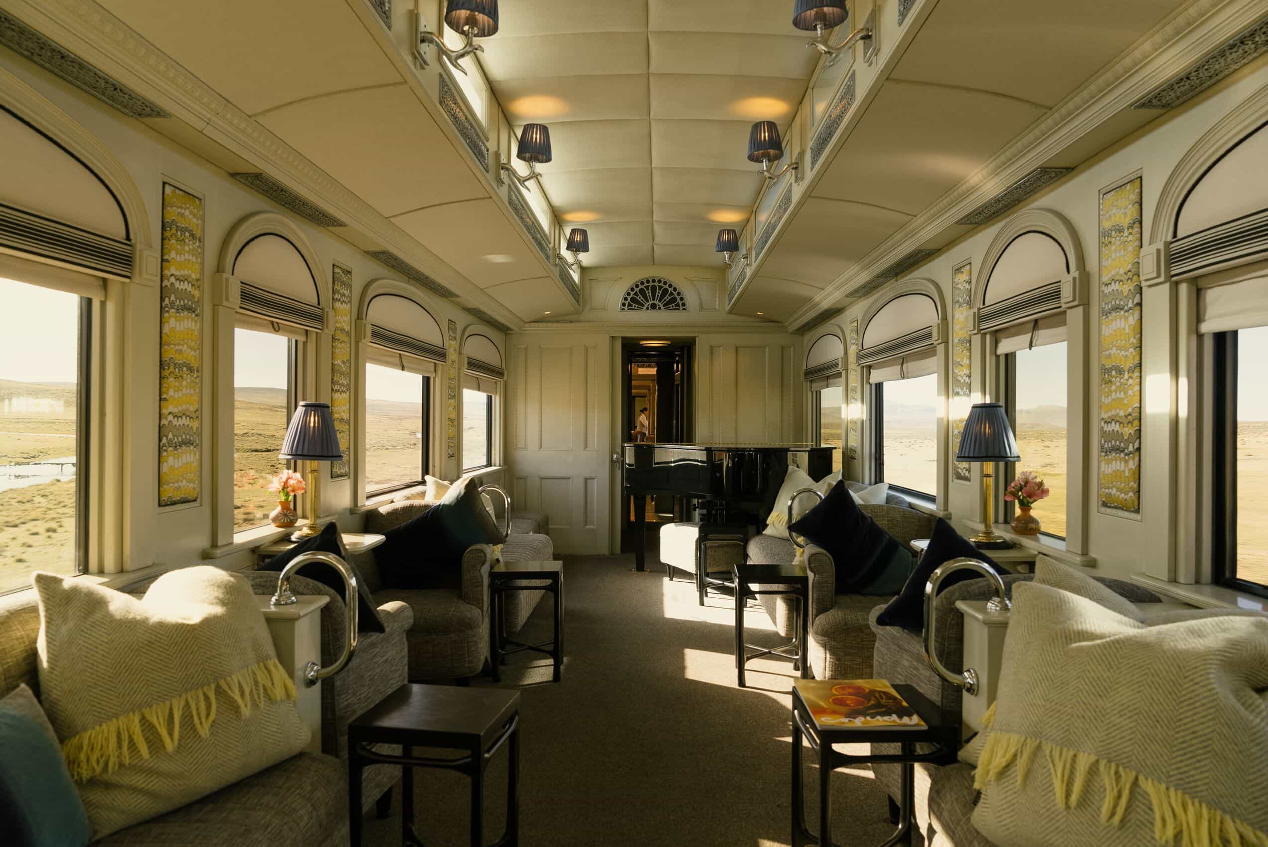 Inside of a luxury train car with black chairs and light grey walls