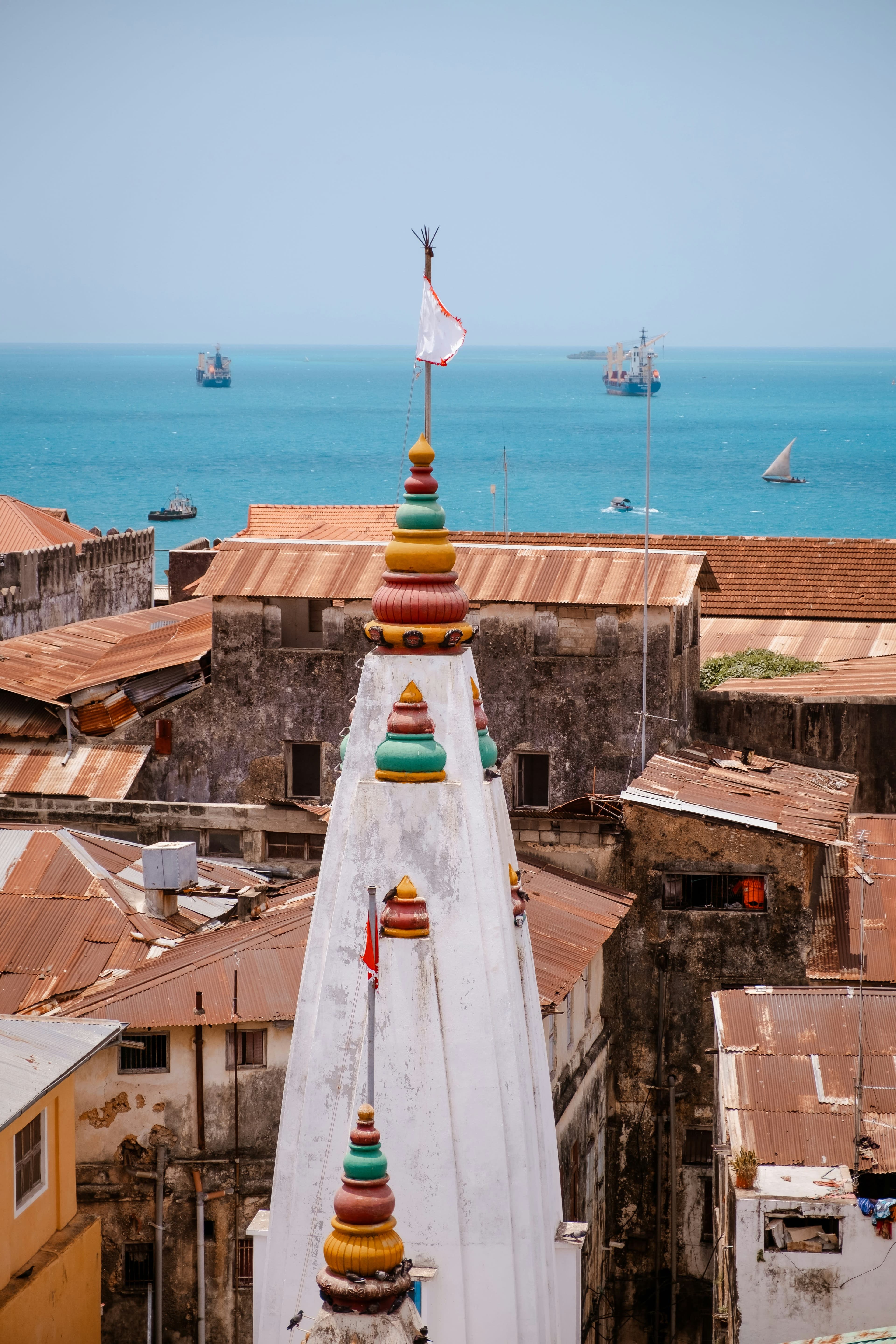 A row of quaint and vibrant houses by a body of water on a sunny day.