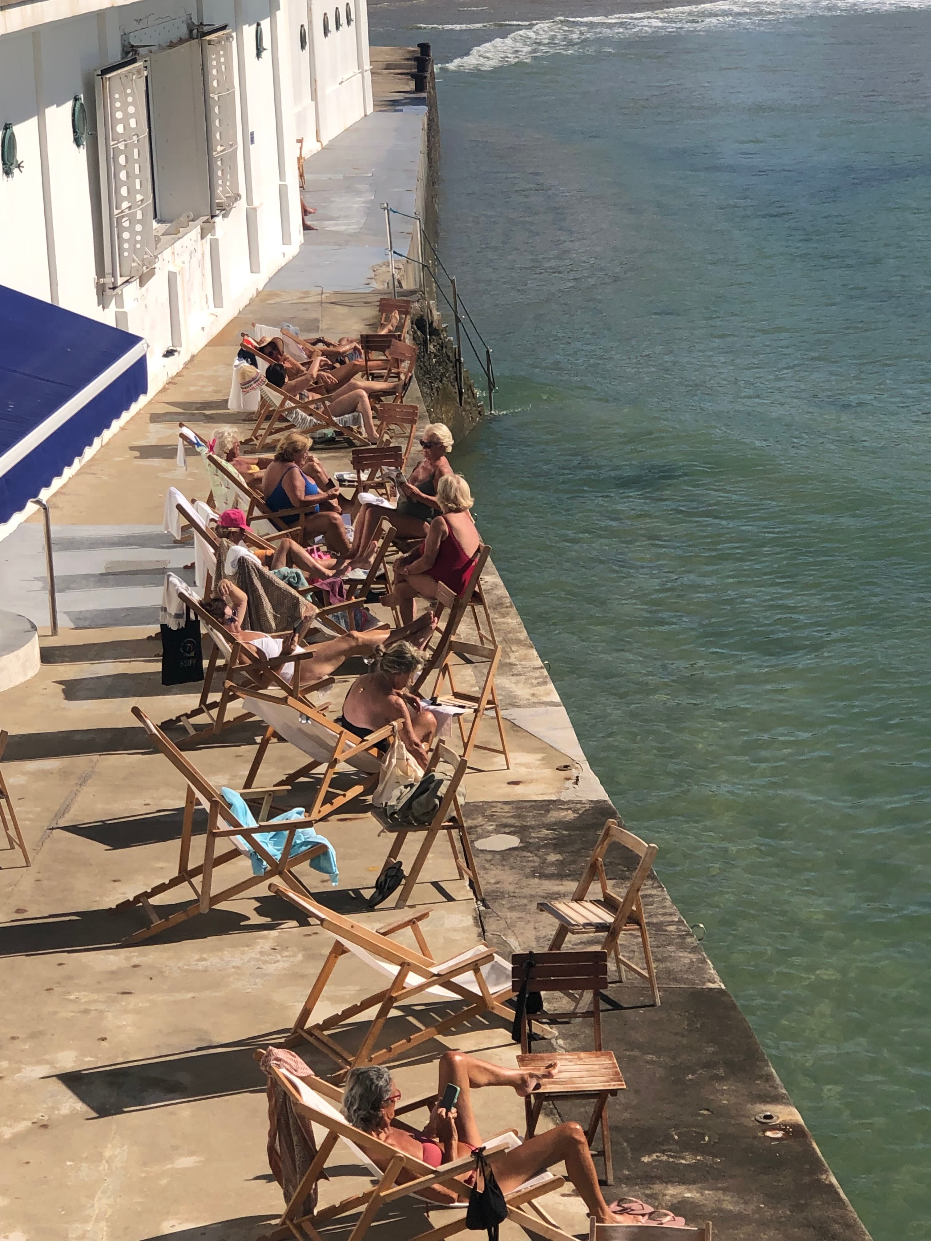 A water way with a patio for sitting on loungers on a sunny day.