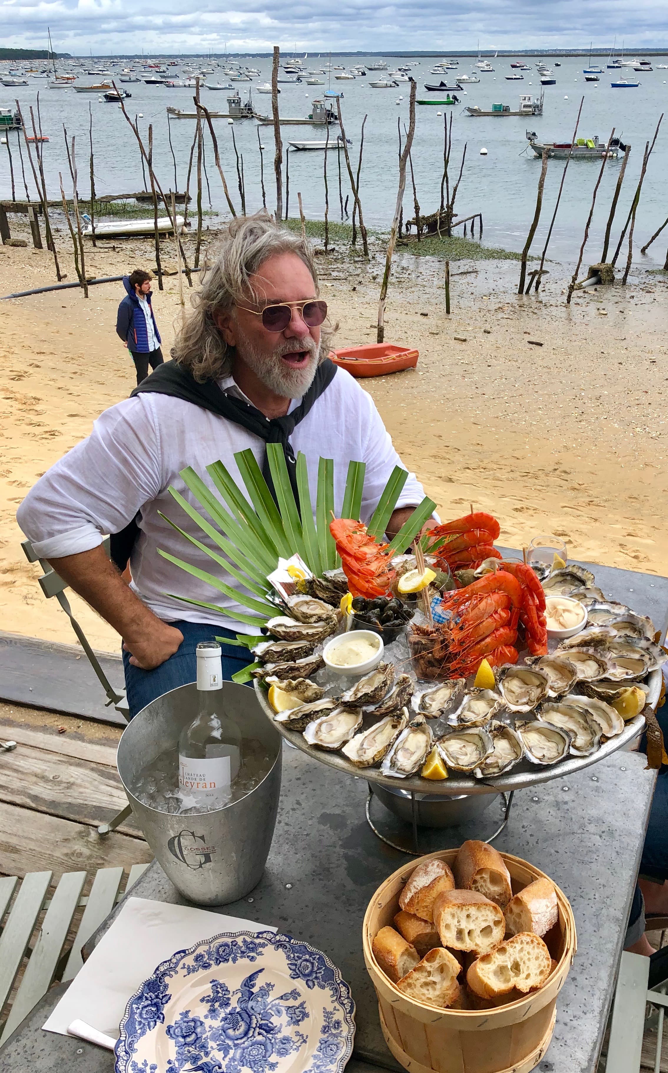 Advisor sitting at lunch on a beach shore with a table of food.