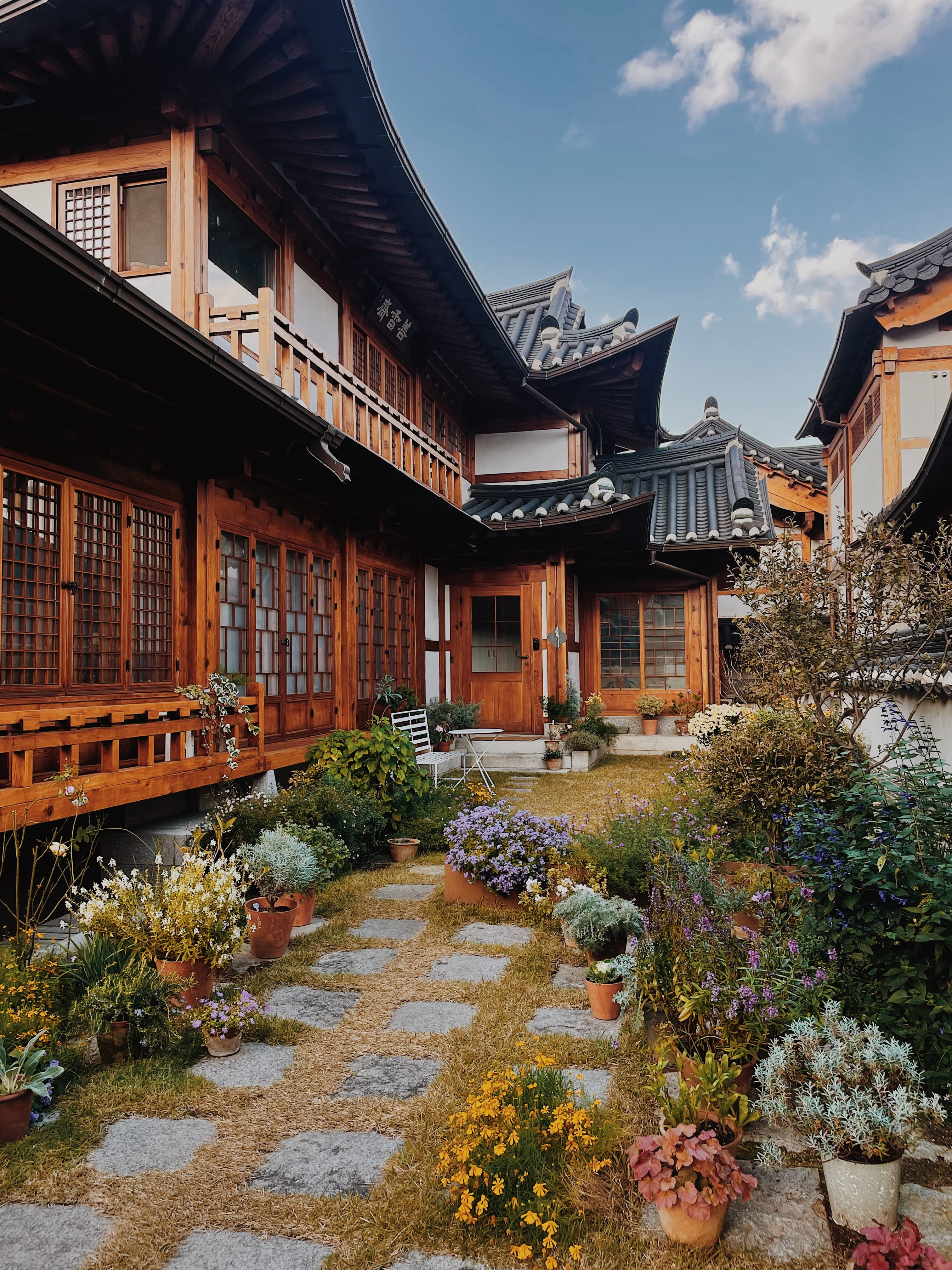 Beautiful picture wooden homes with black rooftops surrounding a small garden under clear skies
