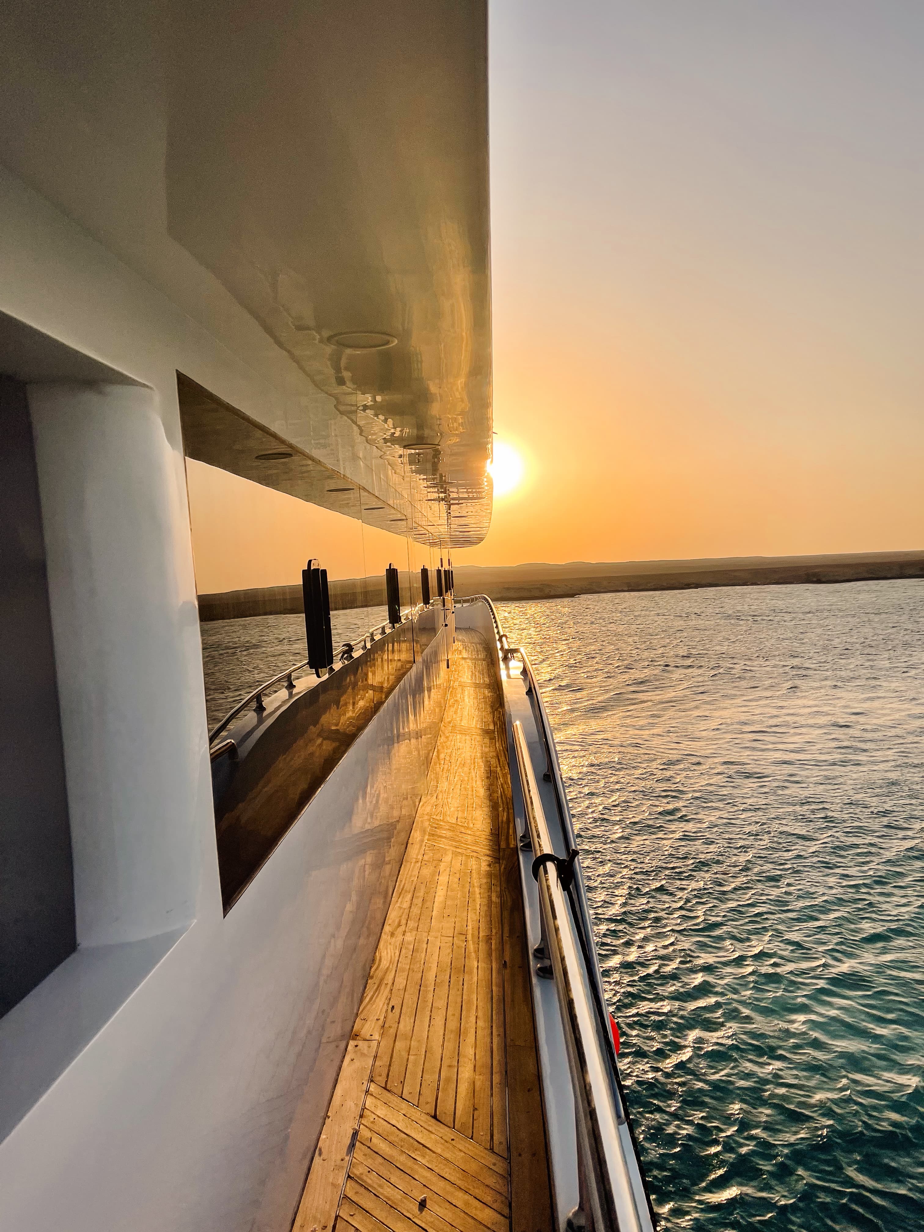 Beautiful view of sunset over the horizon from the side of a yacht out to sea