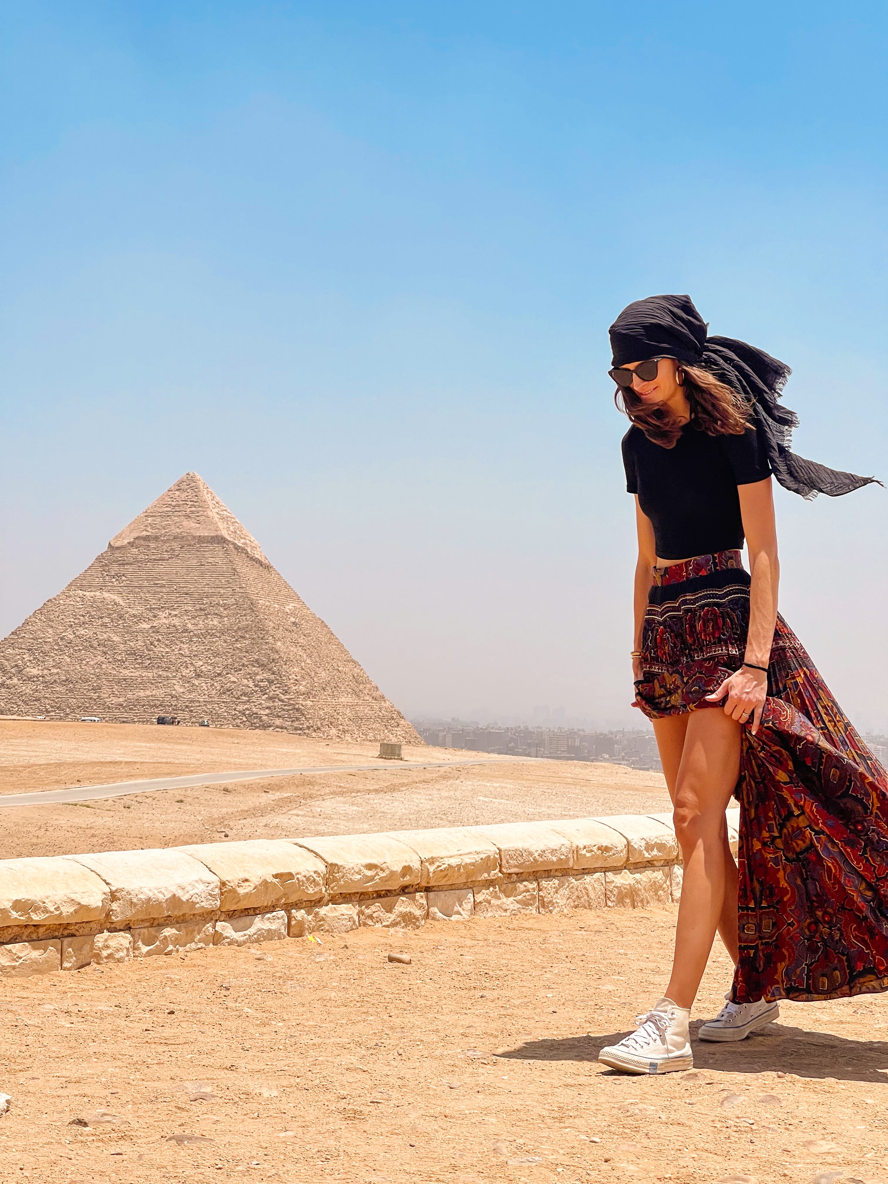 Picture of Florencia wearing a scarf and sunglasses with the great pyramid of Giza in the background on a sunny day