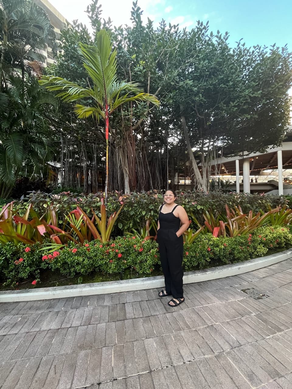 Travel advisor Alyssa standing on a path infront of lush greenery at a resort.