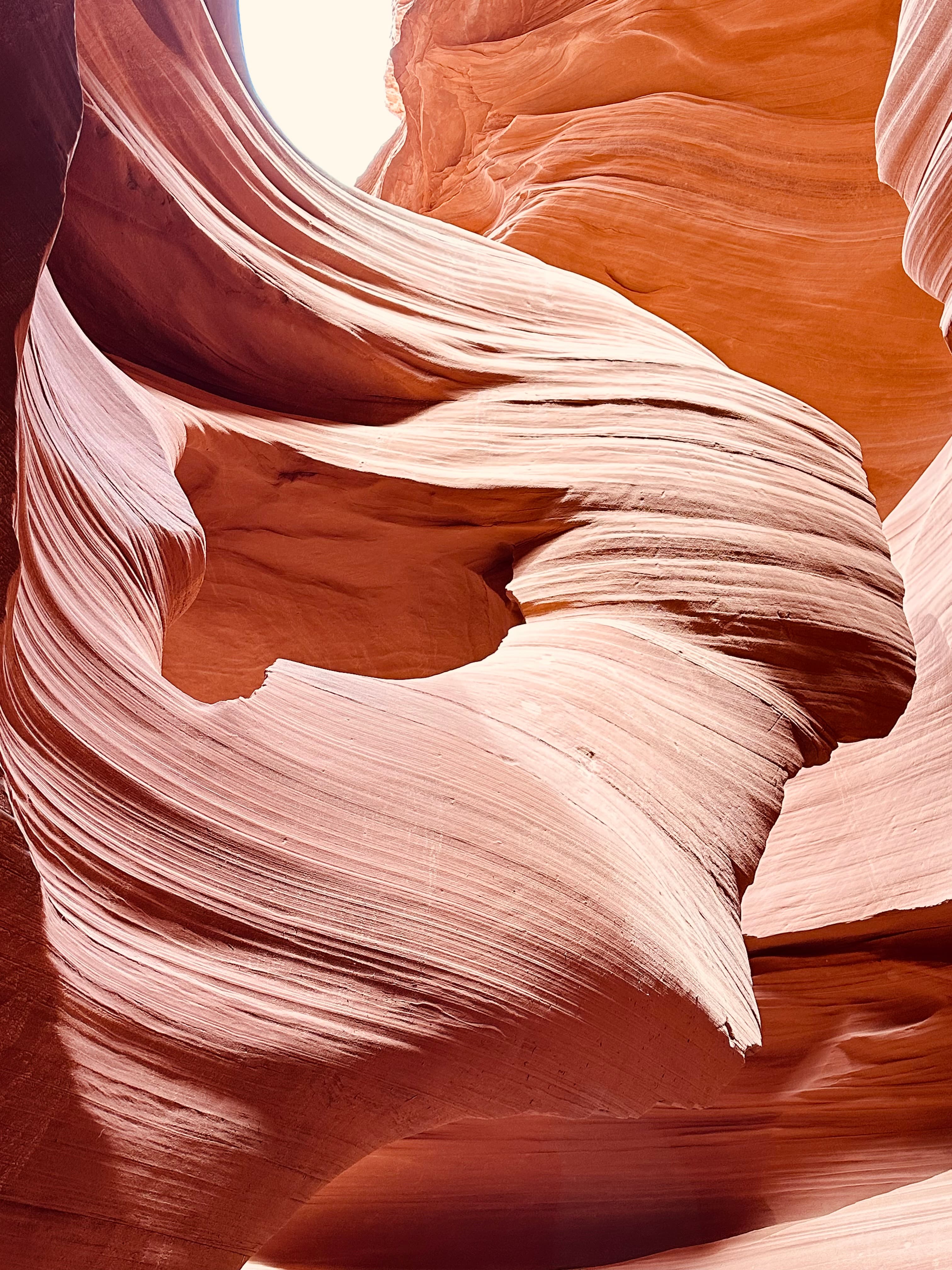 An orange cave with smooth edges in the desert.