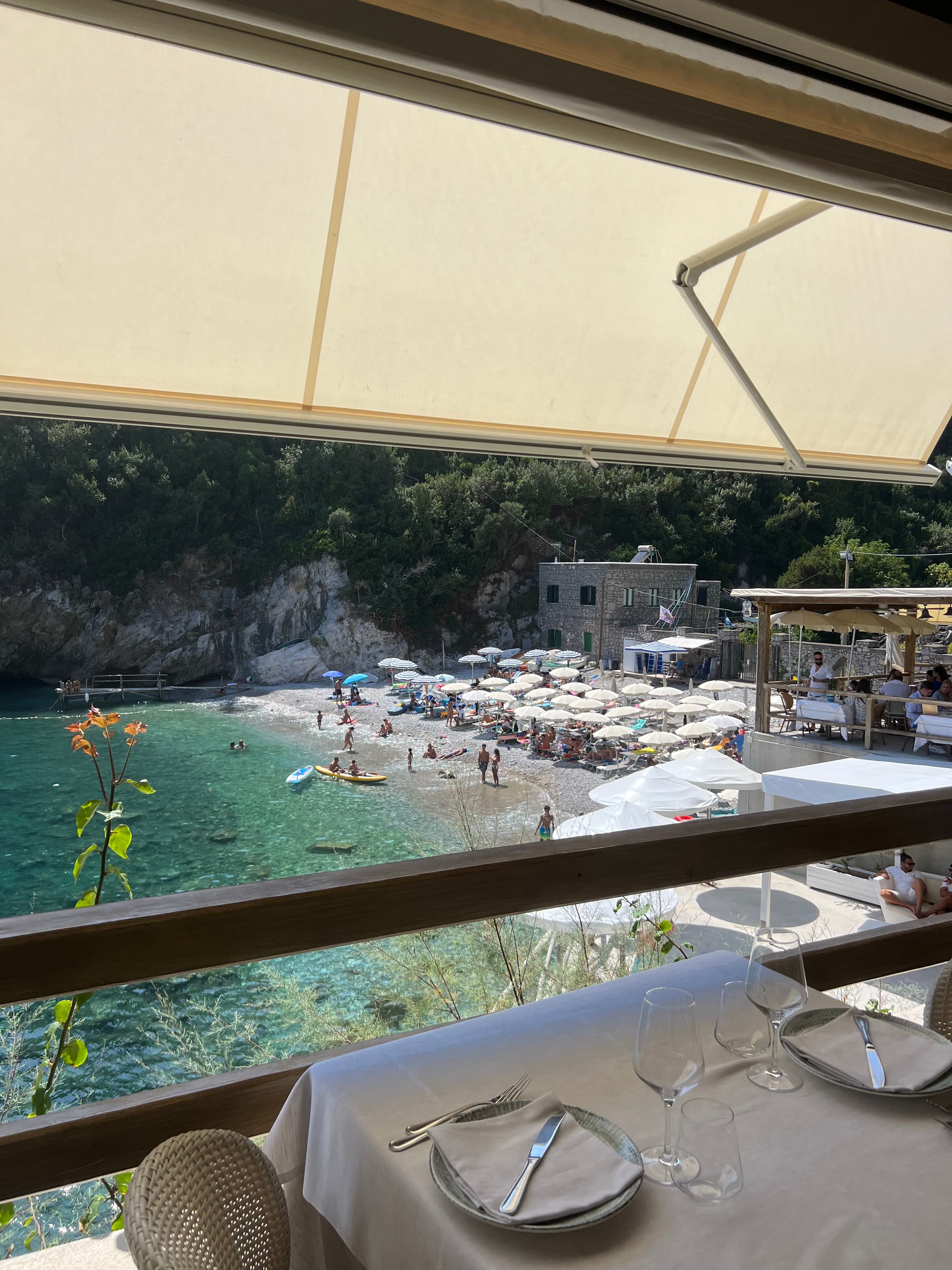 A view from a restaurant balcony of a busy beach.