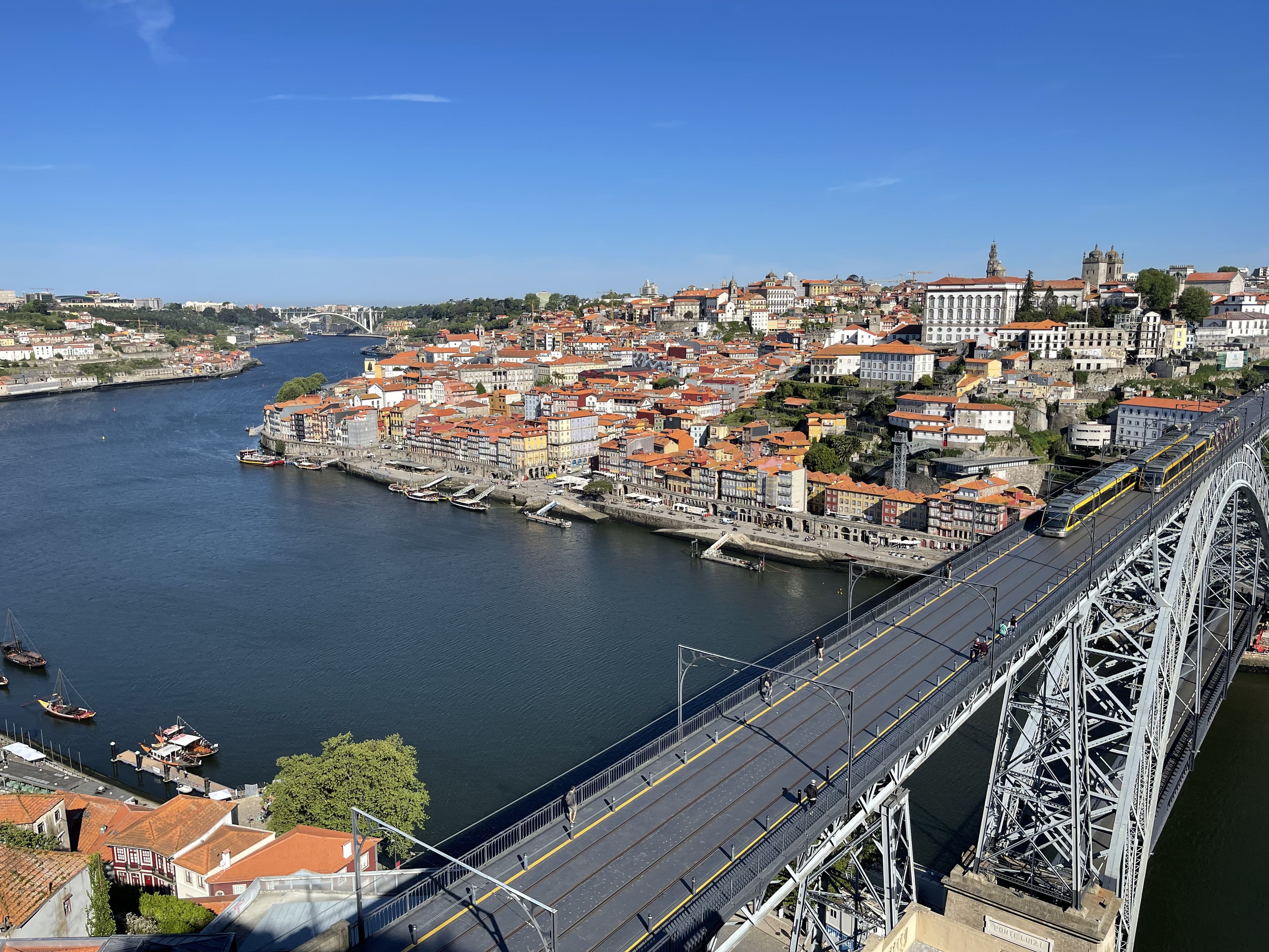 Bridge across a river with red-roof buildings on both sides.