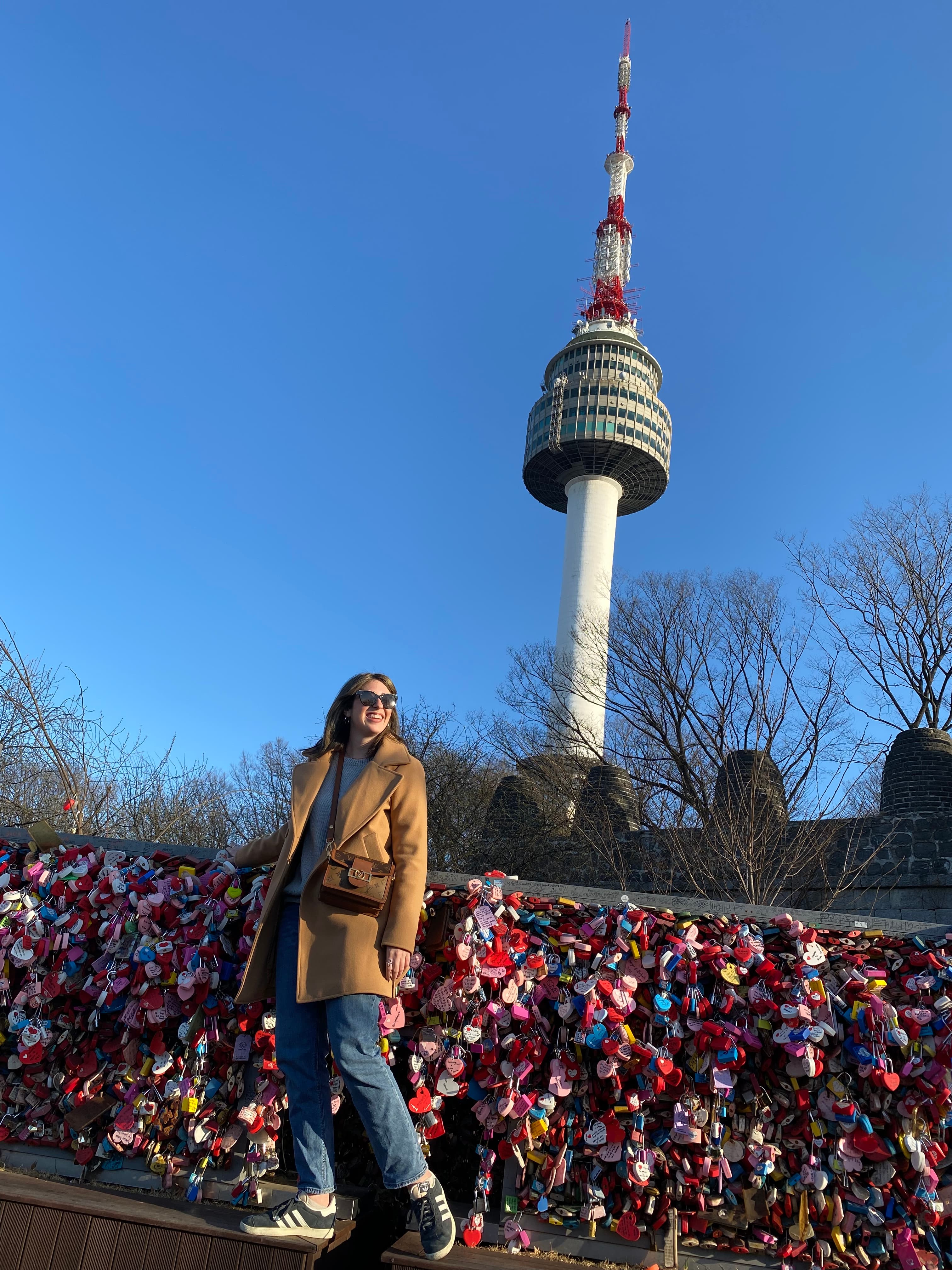 Advisor posing on a bridge with a tall structure in the distance.
