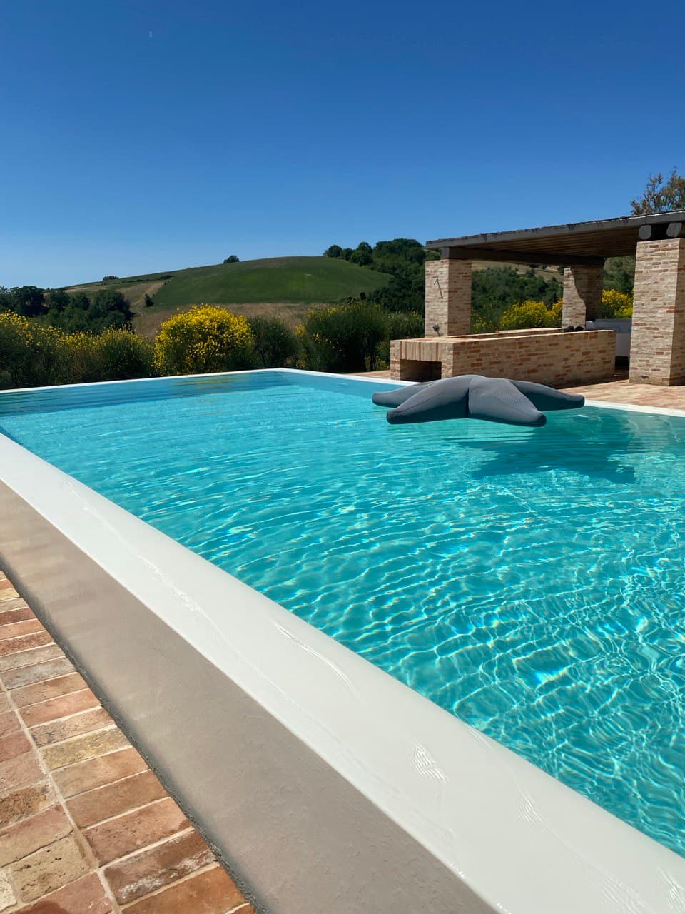 View of a beautiful hotel pool with views of the surrounding hills on a sunny day