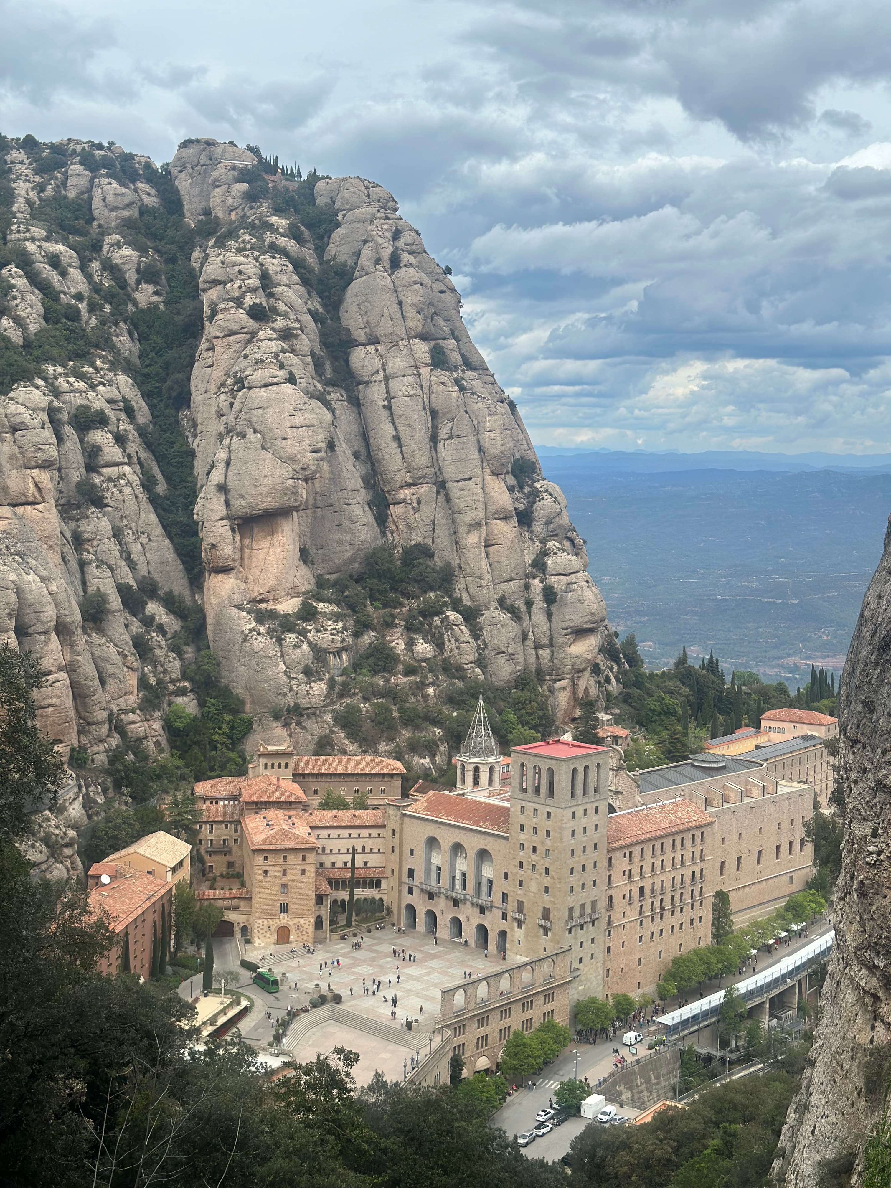 An image of town square at the bottom of a large cliff formation on a sunny day.