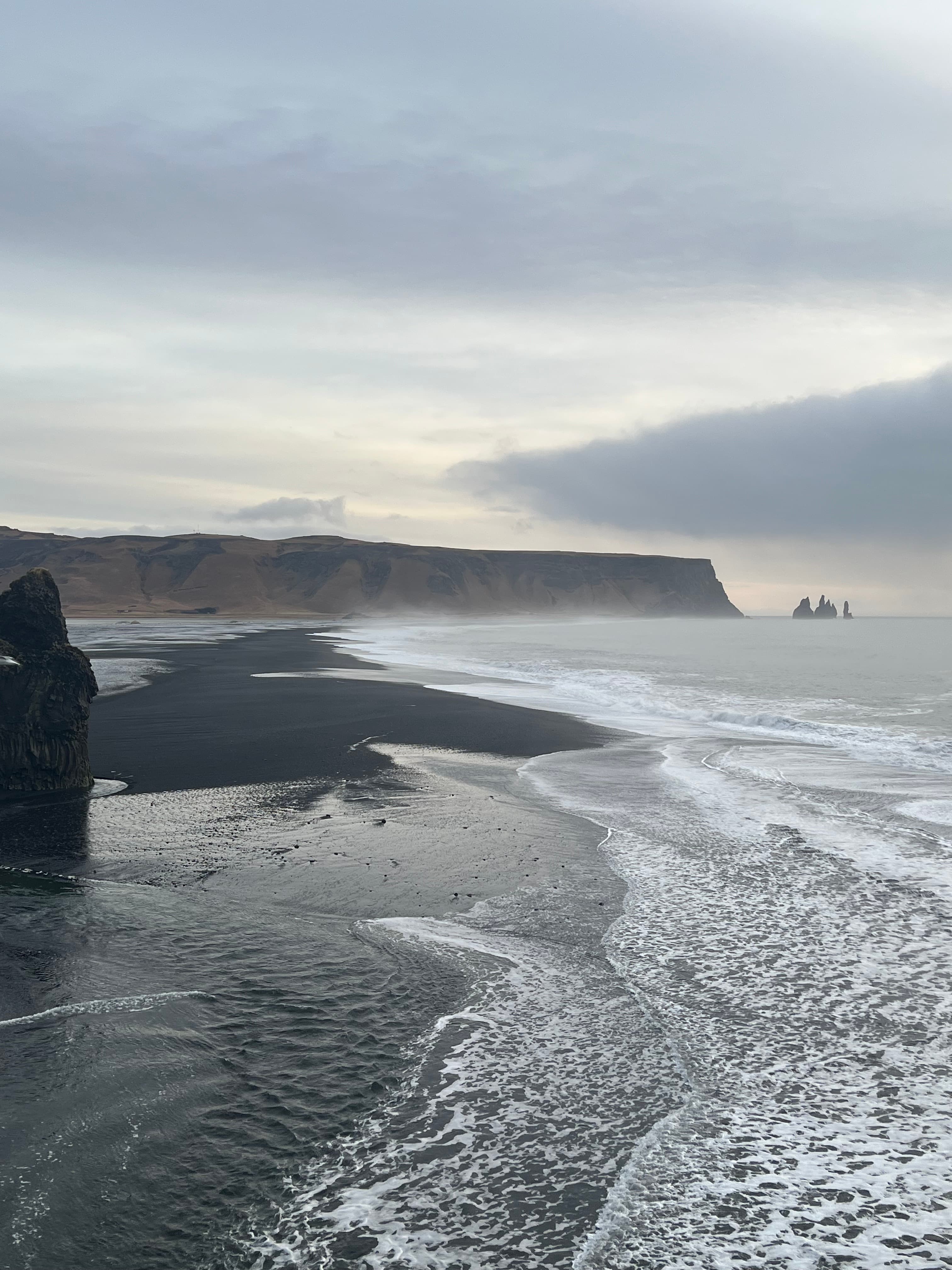 Aerial view of an empty beautiful coastline with cliffs and cloudy skies